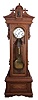 Wm L. Gilbert, Winsted, Conn., "Standing Regulator No. 8" 8 day, time only, weight driven brass movement with Graham deadbeat escapement, maintaining power, gridiron pendulum and sweep seconds in a carved cherry case, the crest with central sphinx head ornament, and Roman numeral white enamel dial.