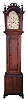 Maine, tall case clock, 8 day, time and bell strike, weight driven movement with unusual cast iron plates in a cherry case with fret work top, ogee feet and two brass finials and painted metal dial.