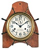 Seth Thomas Clock Co., Thomaston, Conn., "Merrimac" ship's clock, 30 hour, time and ship's bell strike in brass case with radial handles resembling a ship's wheel mounted to pine board to facilitate wall hanging, 5 inch silvered dial.
