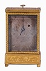 Austria, quarter repeating miniature carriage clock, the rectilinear, gilt brass case on turned feet, front and sides with foliate engraving, carrying handle folding flush with the case top, Roman numeral silvered dial, with engraving matching the case, blued steel hands, round, 30 hour verge fusee movement with blued steel gongs, repeating the last hour and quarter on demand, together with its original leather covered, wooden travel case