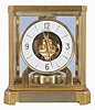 Jaeger- LeCoultre, Switzerland, "Atmos" clock, 15 jewel, caliber 528-8 movement, gilt torsion pendulum, round white painted dial with applied gilt Arabic numerals and arrow markers, gilt hands, all contained in a glazed rectangular case with dedication plaque, serial #128209, c1960.