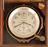 Hamilton Watch Co., Lancaster, Penn., model 21 marine chronometer, 14 jewel key wind and set, straight line damascened nickel plate movement, with spring detent escapement and chronometer balance with helical hairspring, Arabic numeral metal dial with wind indicator, black painted steel spade and poker hands, contained in a gimbaled brass bowl, and mounted in a mahogany box with brass hardware, the inside of the box top with instruction label, and contained in a larger, cherry outer box, serial #2E7317, c1940