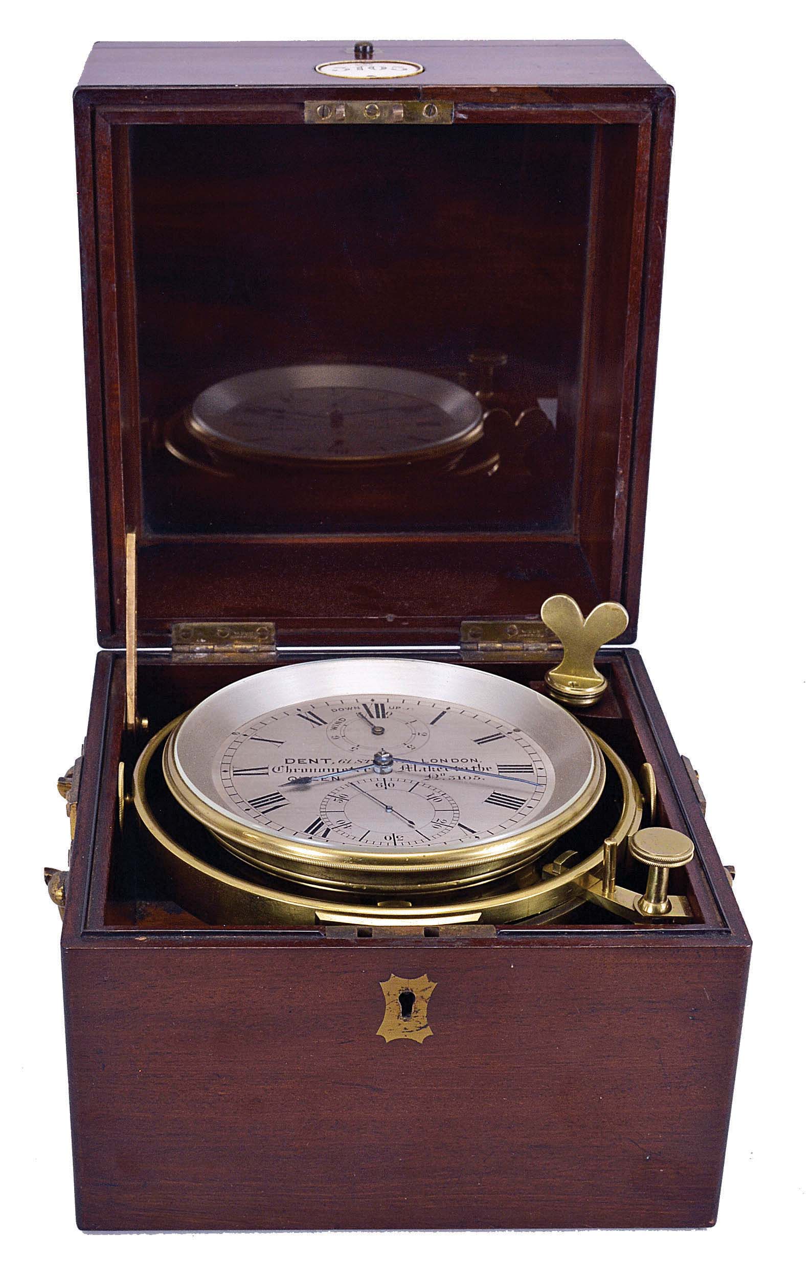 Dent, 61 Strand, London, a rare eight day marine chronometer with Dent's staple balance, 12 jewel, free sprung, reverse fusee movement with Earnshaw's escapement, bimetallic staple balance, blued steel helical balance spring and diamond endstone, Roman numeral silvered dial with wind indicator, blued steel spade and poker hands, contained in a lacquered brass bowl, and mounted in a gimballed mahogany and mahogany veneer box with brass furniture, the front with round plaque marked "3105" — Antique Clocks Price Guide