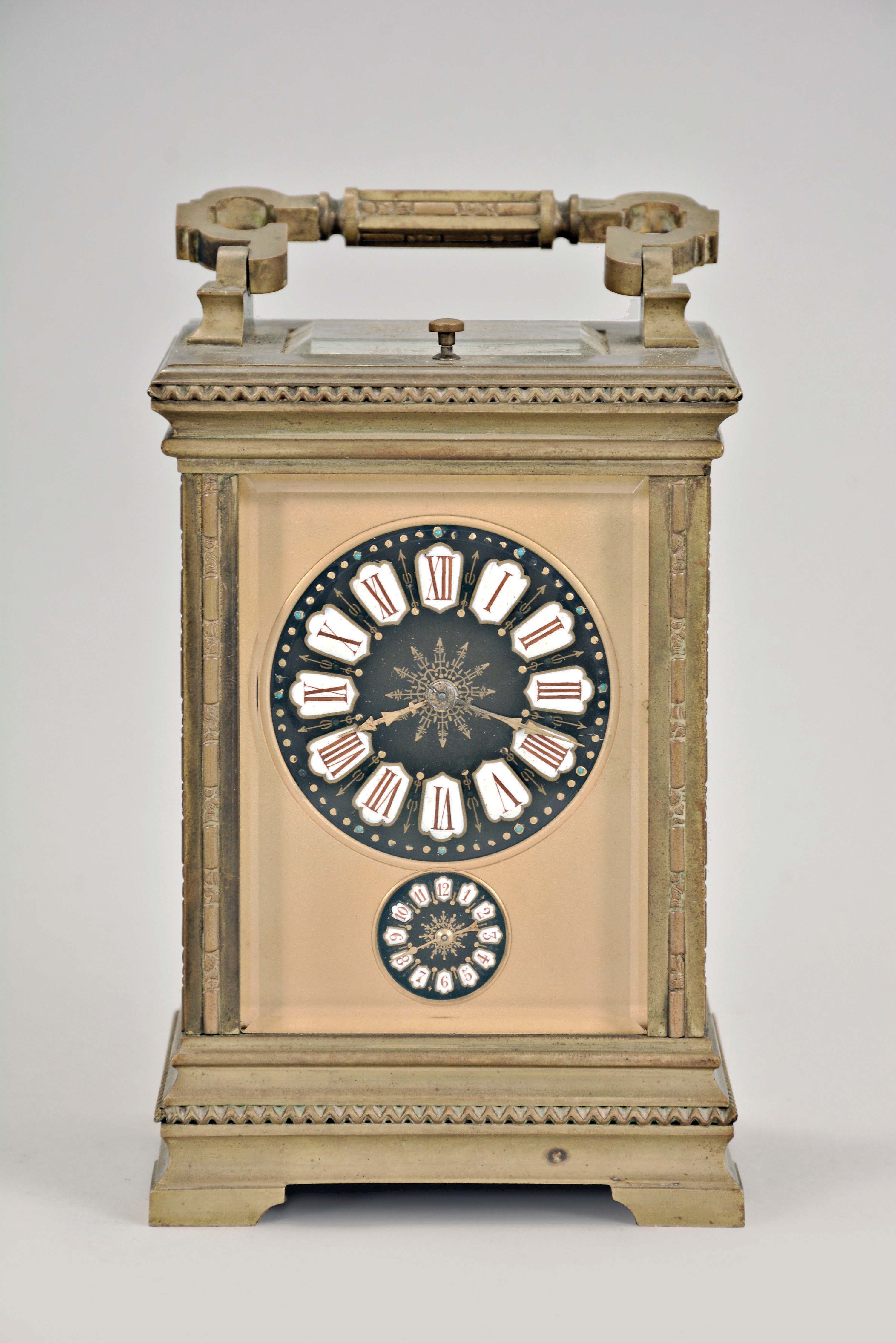 France, for the German market, hour repeating carriage clock with alarm, Anglaise variant case with beveled glasses, Roman numeral black enamel dial with integral white cartouches, gilt mask, and subsidiary alarm dial, gilt distaff hands, 8 day, time, strike, and alarm movement with lever platform and cut, bimetallic balance, sounding the hour and half hour in passing, and repeating the last hour on demand — Antique Clocks Price Guide
