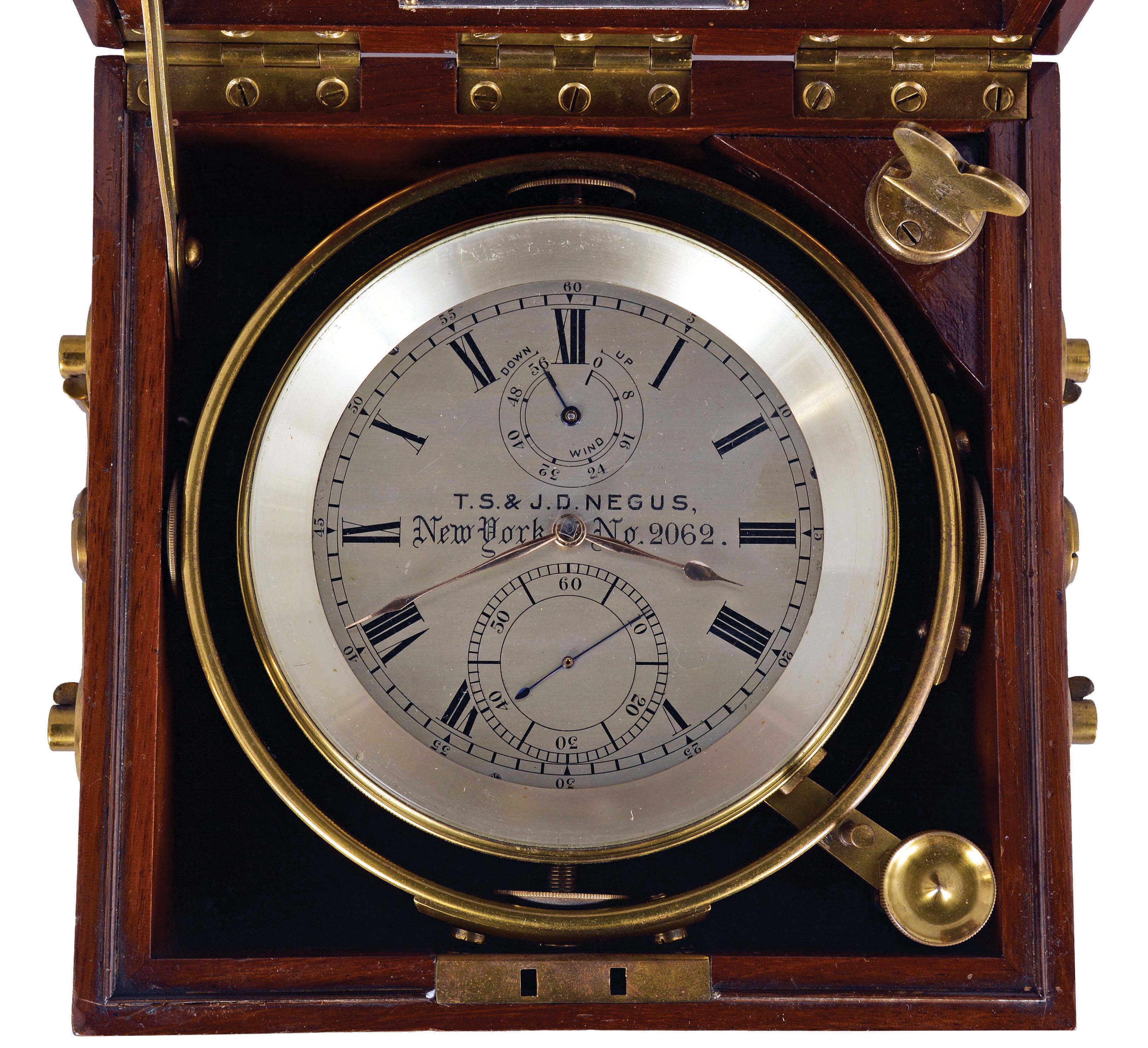 T.S. & J.D. Negus, New York, two day marine chronometer, 11 jewel fusee movement with spotted plates, Earnshaw's escapement, freesprung, cut bimetallic "H" balance, diamond endstone, and blued steel helical balance spring, Roman numeral silvered dial with wind indicator and gold spade and poker hands, contained in a gimballed, lacquered brass bowl, all in a three tier mahogany box with brass furniture, serial #2062 — Antique Clocks Price Guide