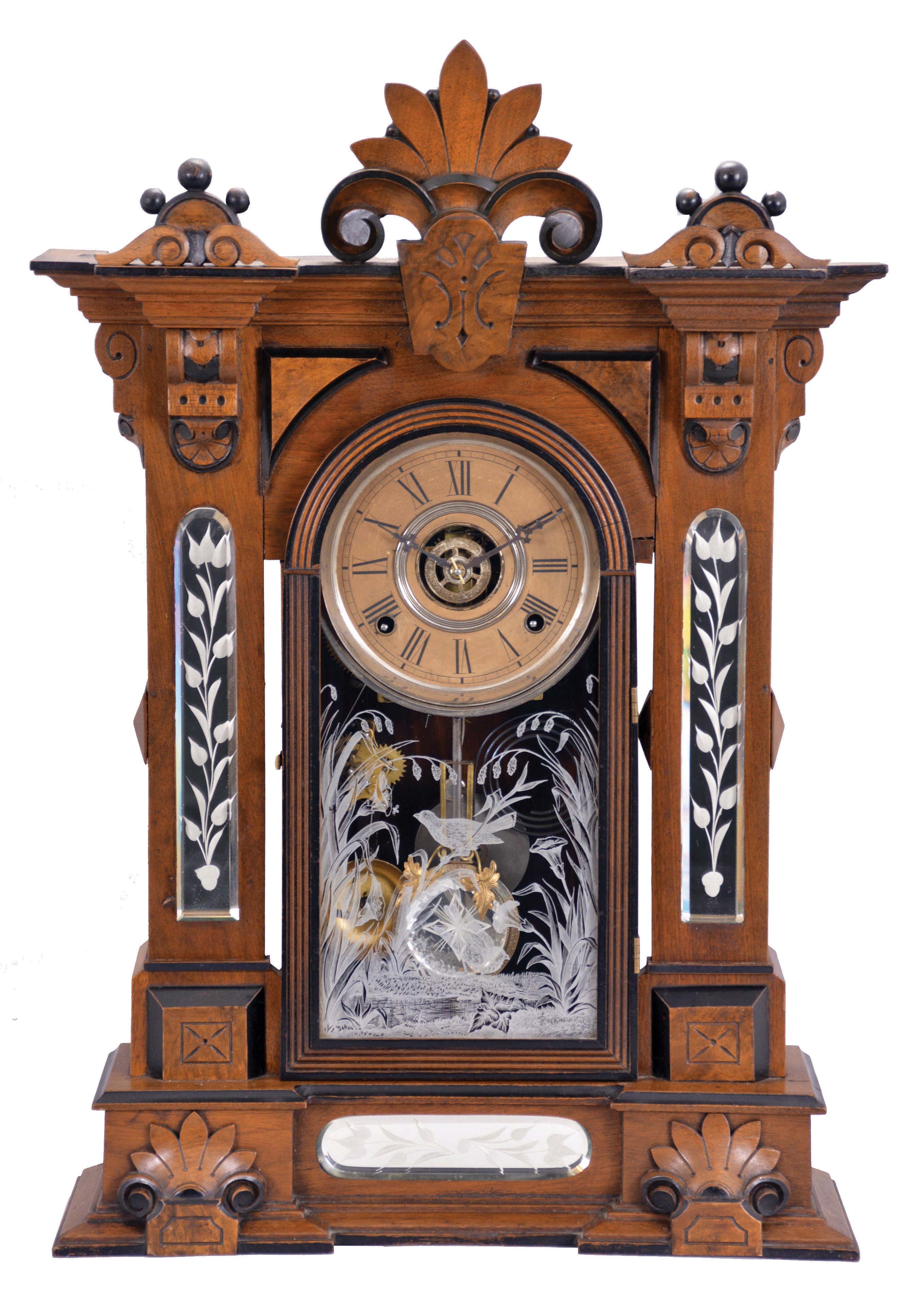 William L. Gilbert Clock Co., Winsted, Conn., "Amphion" shelf clock with a spring driven, 8 day, time, strike and alarm movement in a walnut case with burl accents and cut glass mirror panels in the case adjacent to and below the door. — Antique Clocks Price Guide