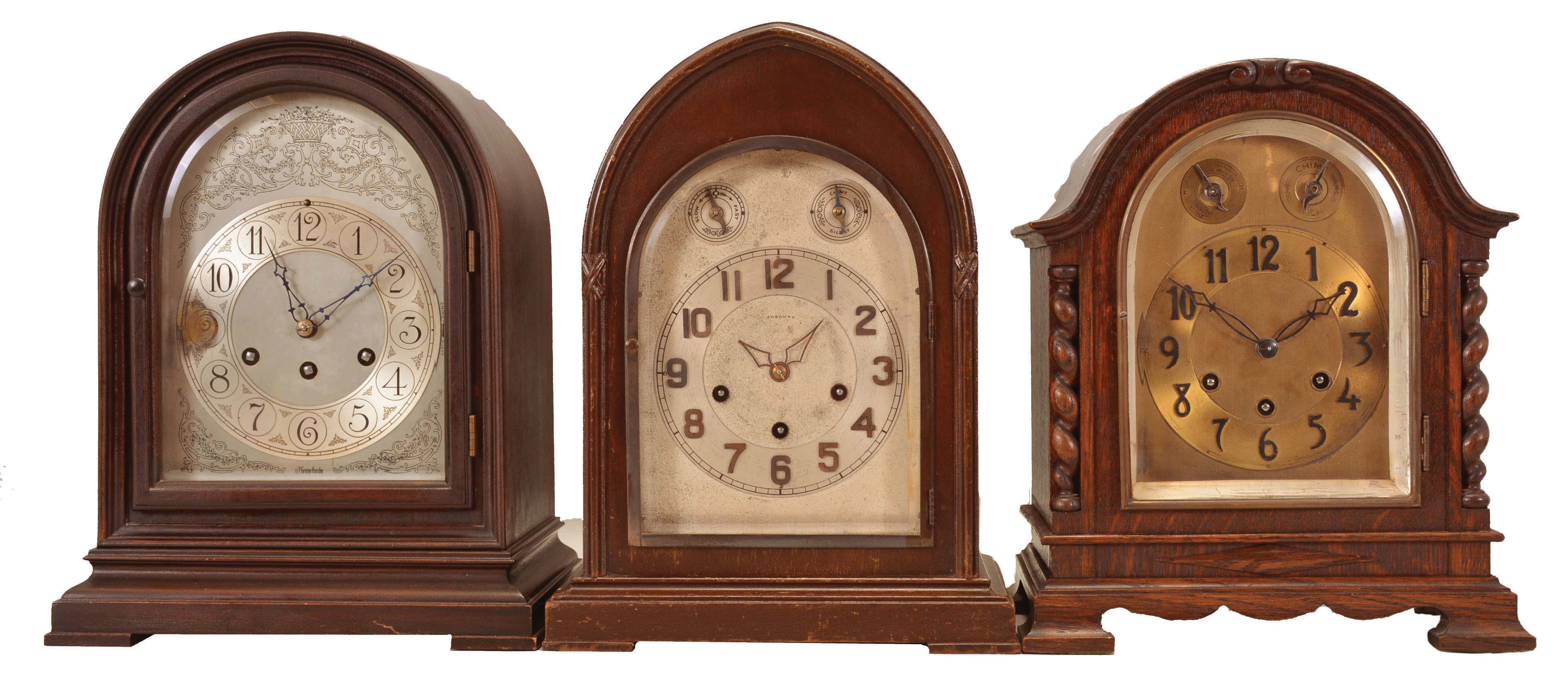 Clocks- 3 (Three) Chiming Mantel: (1) Herschede Clock Co., Cincinnati, OH, chiming mantel clock, 8 day, time and strike with Westminster chime playing on 5 rods, spring-driven movement, serial number 25093 in a round gothic mahogaNew York case, silvered dial with engraved floral motif, c1920; (2) Ansonia Clock Co., Brooklyn, New York, "Sonia No. 4" chiming mantel clock, 8-day, time and strike with Westminster chime in a lancet walnut case with arched silvered dial with raised bronze numerals and subsidiary dials for setting the rate and chime/silent, c1925; (3) Gustav Becker, GermaNew York, chiming mantel clock, 8 day, time and strike with Westminster chime, spring-driven movement in an arch top oak case flanked by barley twist columns, beveled glass door, dial with applied bronze numerals and subsidiary dials for rate adjustment and chime/silent selector, c1900. — Antique Clocks Price Guide