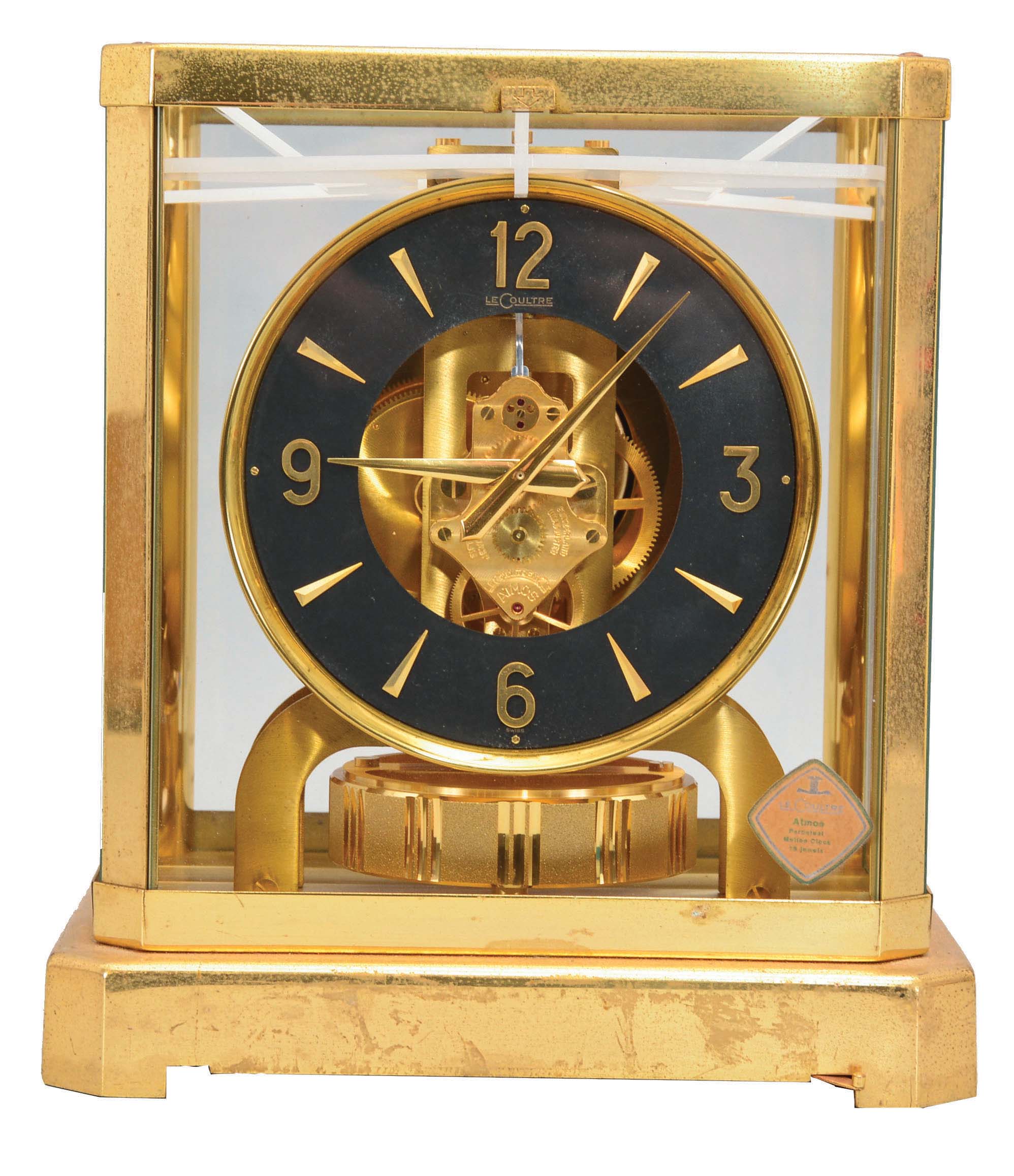 Jaeger- LeCoultre, Switzerland, "Atmos" clock, 15 jewel movement, gilt torsion pendulum, round black painted dial with applied gilt Arabic numerals and arrow markers, gilt hands all contained in a glazed rectangular case with removable front panel, serial #355823. — Antique Clocks Price Guide