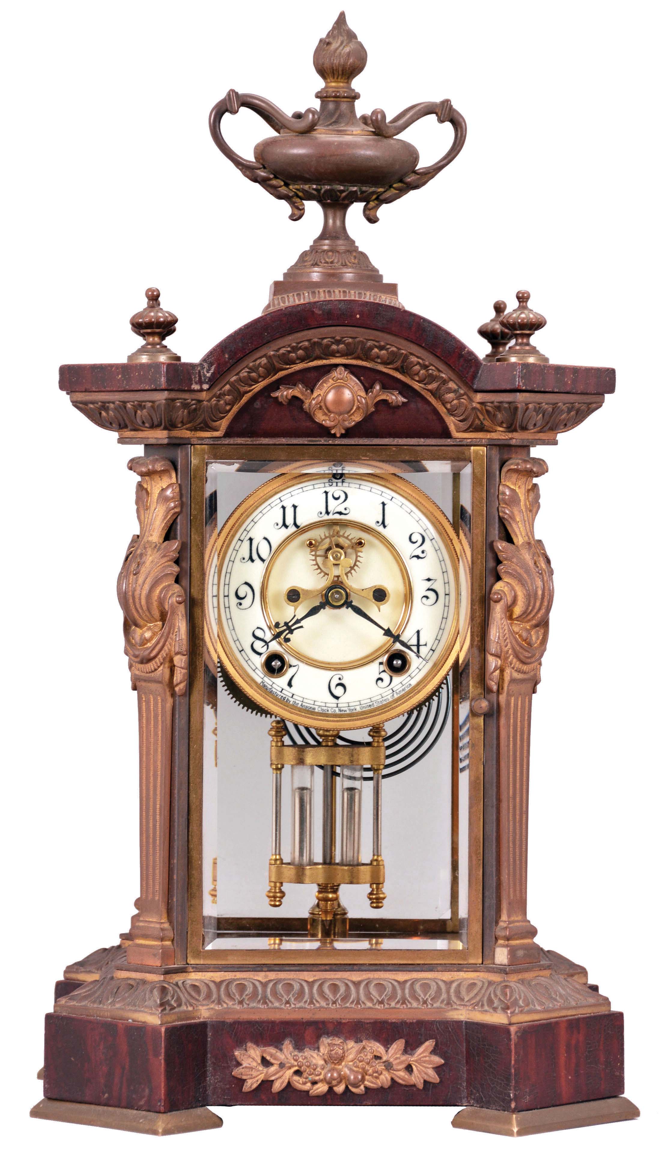 Ansonia Clock Co., New York, "Paragon" Crystal Regulator shelf clock with a spring driven, 8 day half hour strike movement with visible escapement in a bronze case with a rich gold finish and a mahogany base and top. — Antique Clocks Price Guide