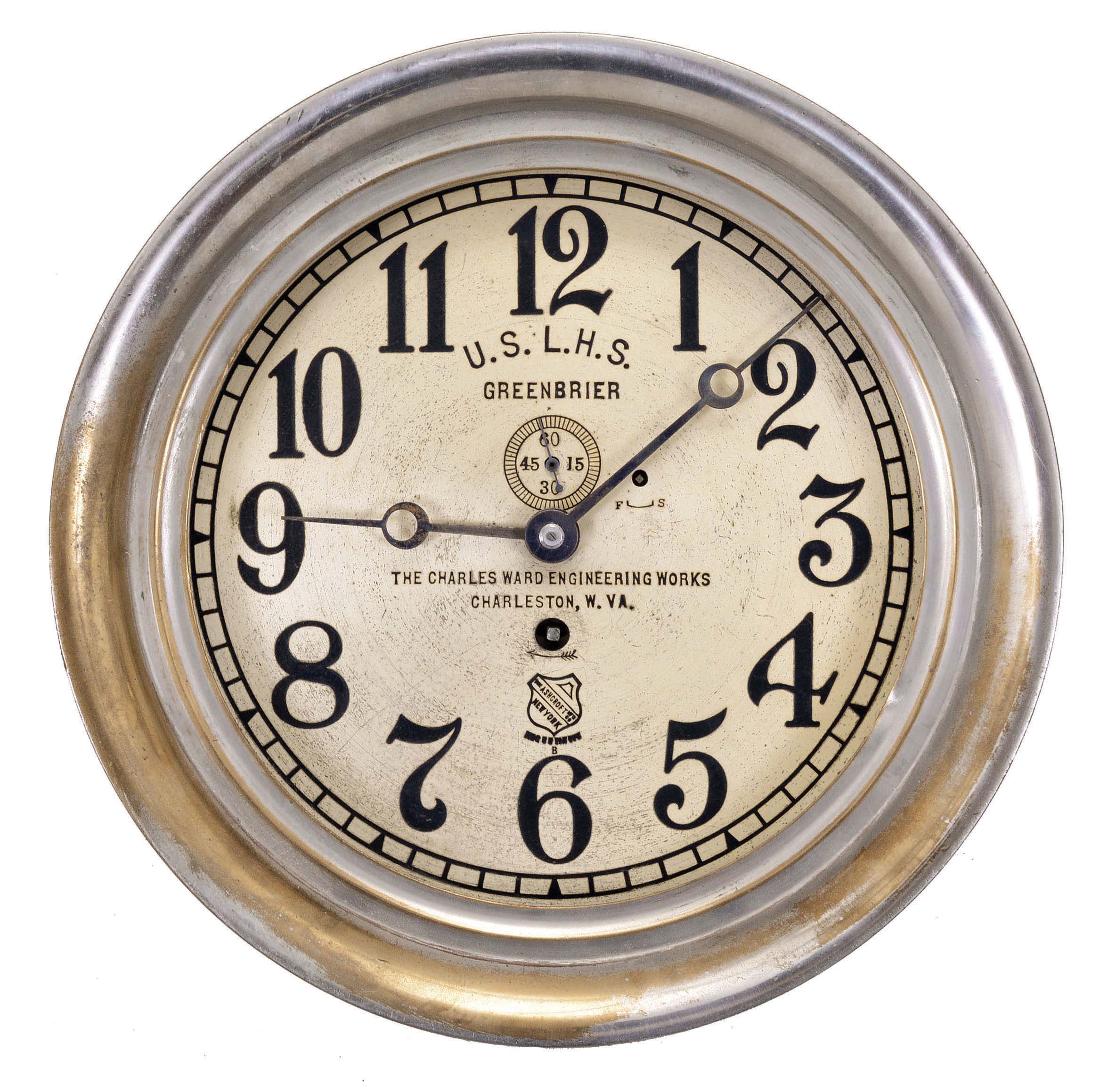 Chelsea Clock Co., Boston, Mass., for Ashcroft Mfg. Co., New York, engine or ward room clock, 8 day, time only, spring-driven jeweled balance wheel movement in a nickel-plated brass case with locking hinged bezel, 8 inch silvered dial with subsidiary seconds, the Ashcroft trademark, small lettering reading "The Charles Ward Engineering Works / Charleston, W. VA.", and bold lettering reading "U.S.L.H.S. / GREENBRIER". — Antique Clocks Price Guide