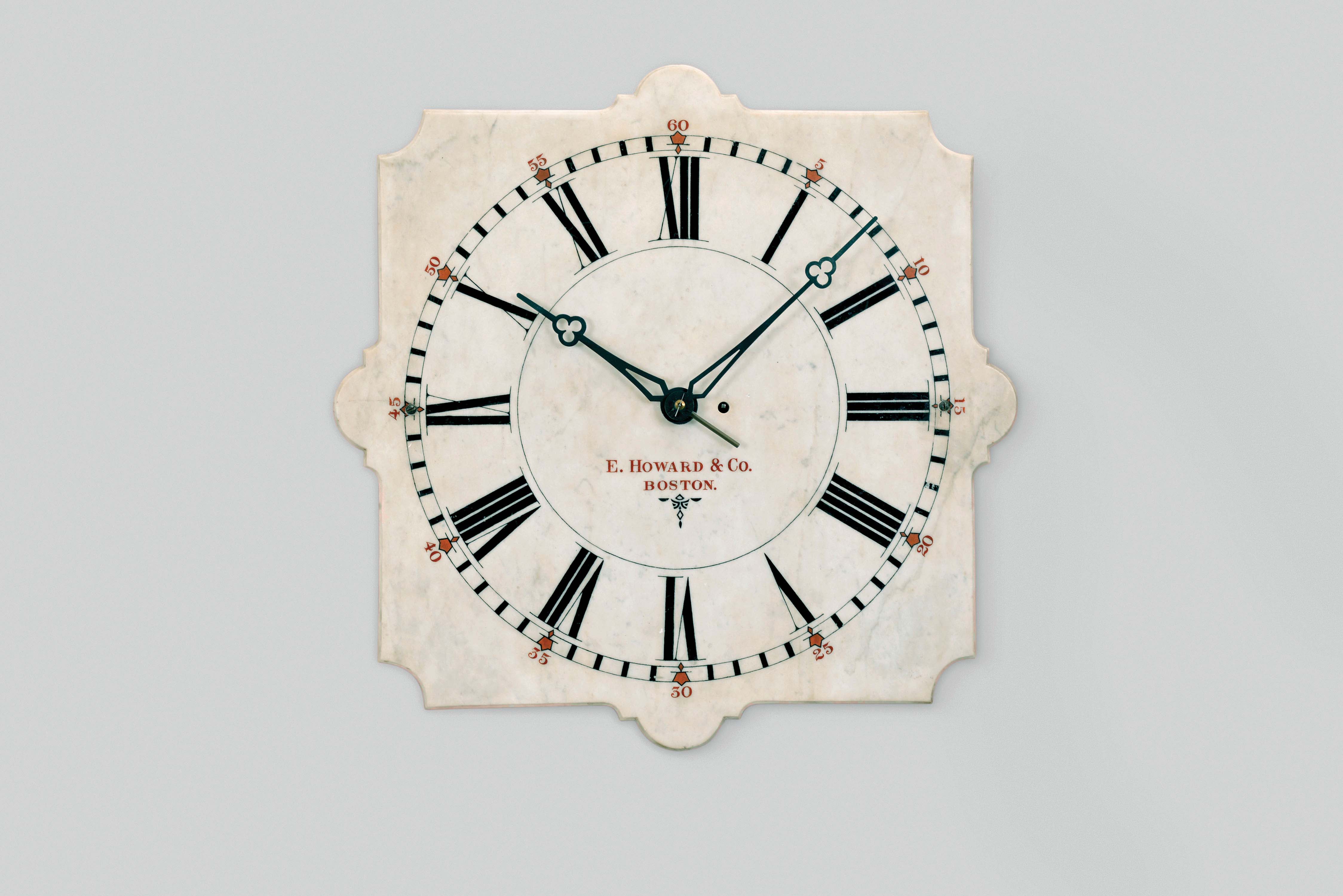 E. Howard & Co., Boston, Mass., "Marble Dial No. 20" wall clock, 8 day, time only, weight driven movement with maintaining power in white painted wood case with 24 inch white marble dial, black painted chapter ring and Roman numerals with red arabic five minute markers, signed "E. Howard & Co. / Boston" in red below the center arbor, black trefoil hands. — Antique Clocks Price Guide