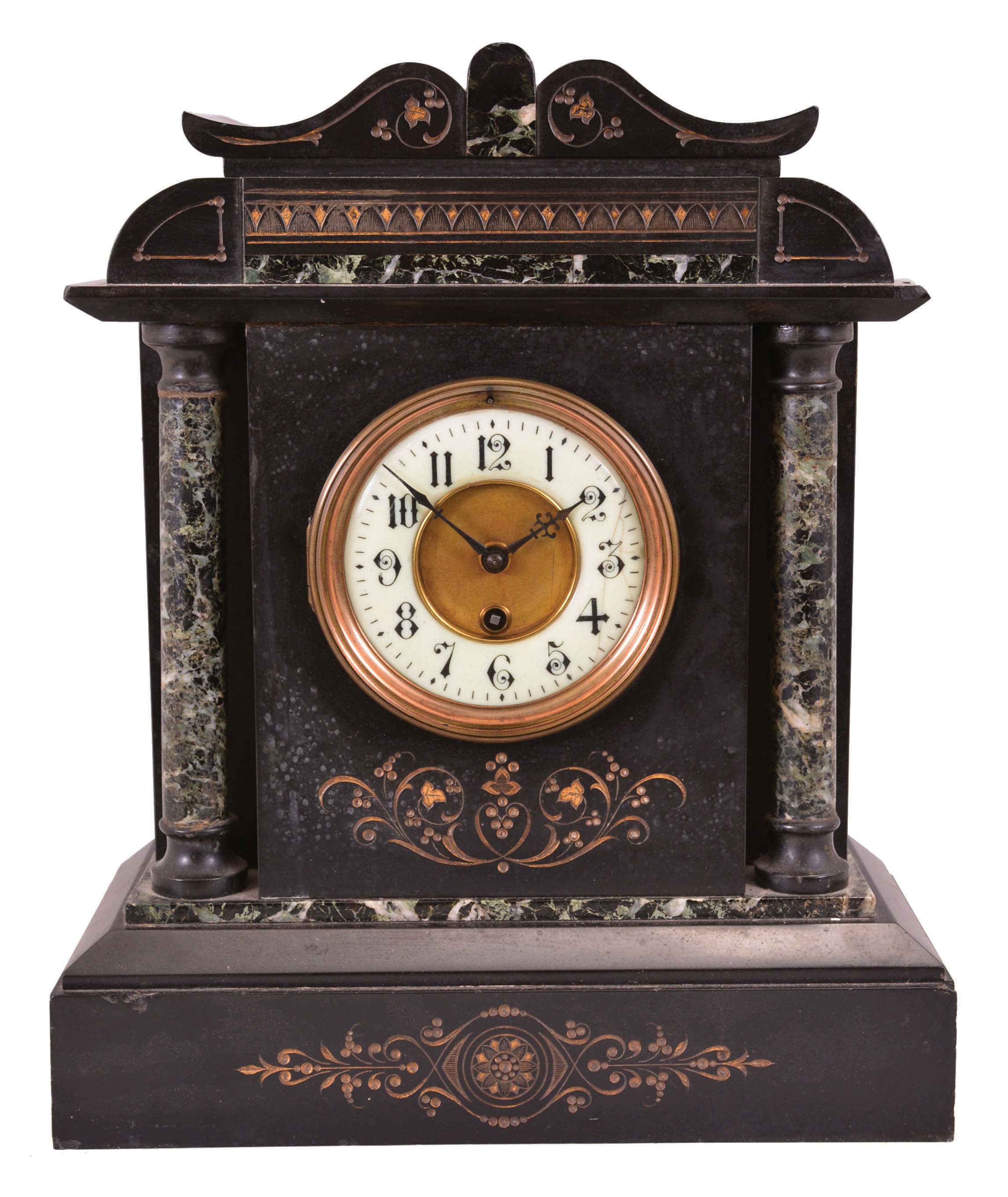France, mantel clock, 8 day, time only, spring-driven movement in incised black slate case on base with chamfered edges, supporting two full columns of green marble that flank a white porcelain dial with Arabic numerals and blued steel hands, the case topped with a frieze and pediment with matching green marble accents. — Antique Clocks Price Guide