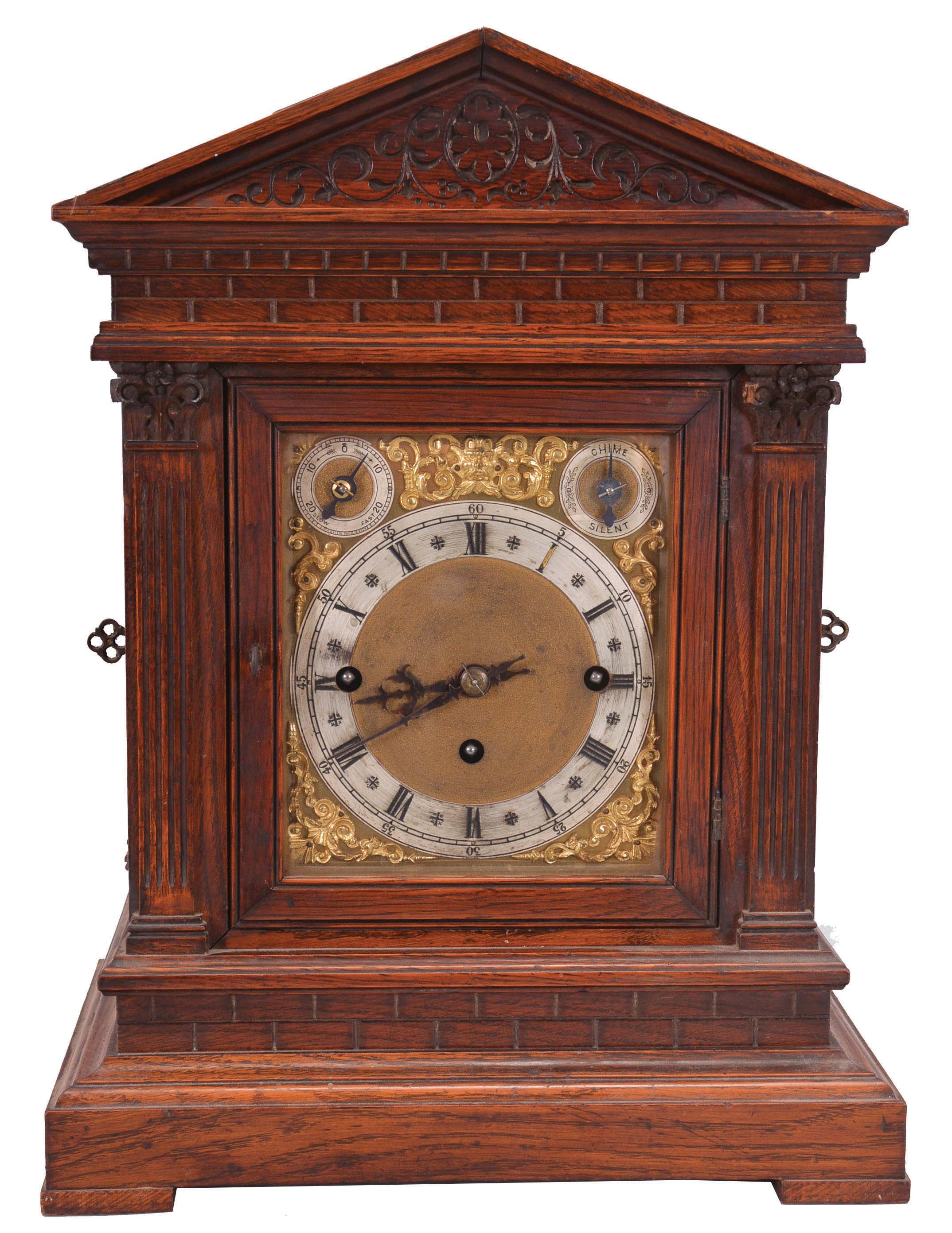 Winterhalder & Hofmeier, Schwarzenbach, Germany, bracket clock, 8 day, time and strike with Westminster chime playing on four gongs, triple fusee movement in an oak architectural case with fluted pilasters, frieze meant to resemble ashlar, tympanum with carved floral design, brass dial plate with applied cast spandrels, silvered chapter ring with Roman numerals, subsidiary rate adjustment and chime / silent dials, blued steel hands. — Antique Clocks Price Guide