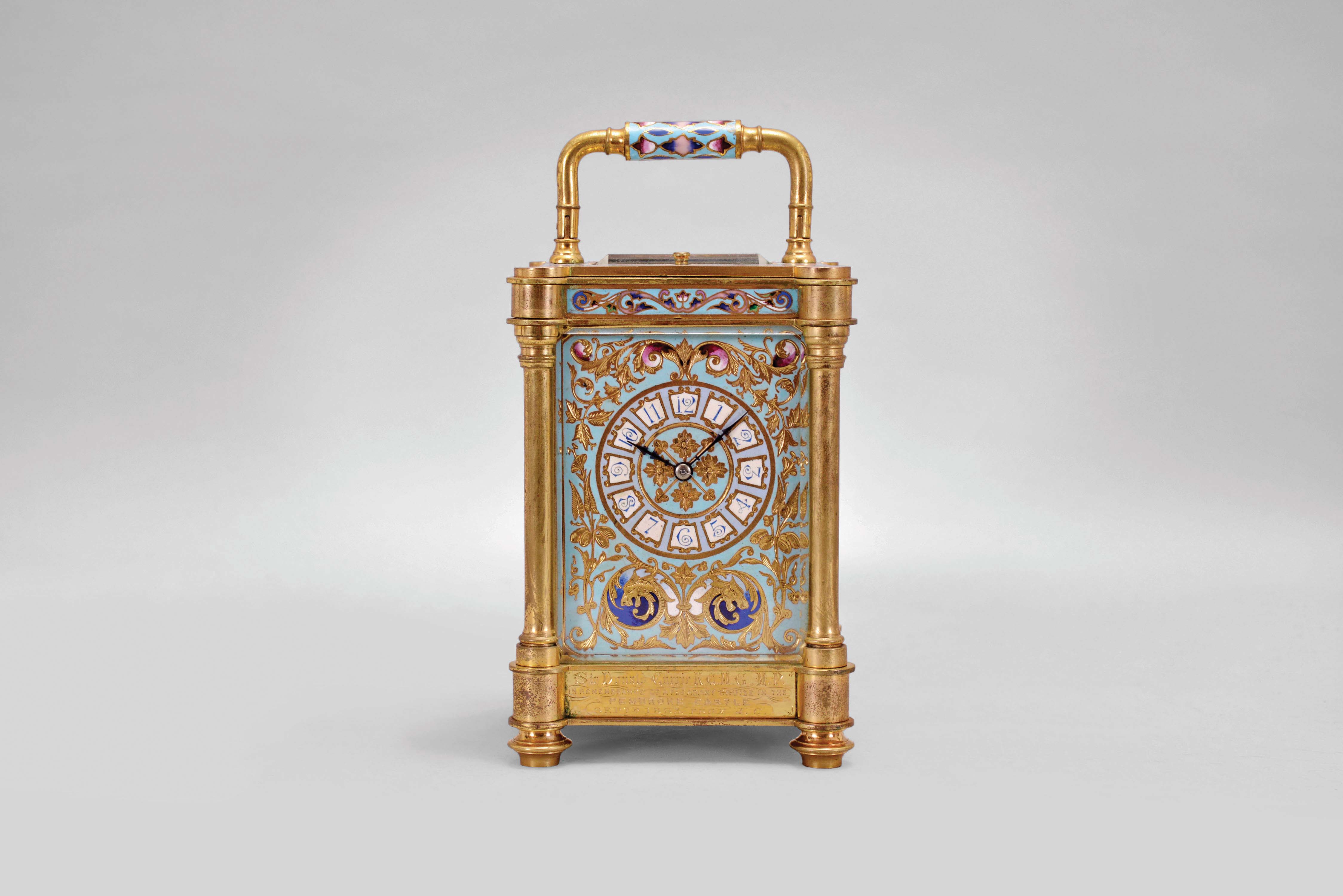 France, an unusual, champleve enamel decorated, pillars style hour repeating carriage clock, the gilt case with outset corners, turned feet and columns, the base, frieze, and top with scrolling foliate designs, and decorated with polychrome enamel colors on a turquoise ground, the front of base with engraved presentation "Sir Donald Currie, K.C.M.G., M.P. In Remembrance of a Pleasant Cruise in the Pembroke Castle, Septr. 1883, from J.C.", Arabic numeral champleve enamel dial with fine engraving and matching the exterior colors, blued steel distaff hands, two train movement with lever platform, striking the hours and half hour in passing, and repeating the last hour on demand — Antique Clocks Price Guide