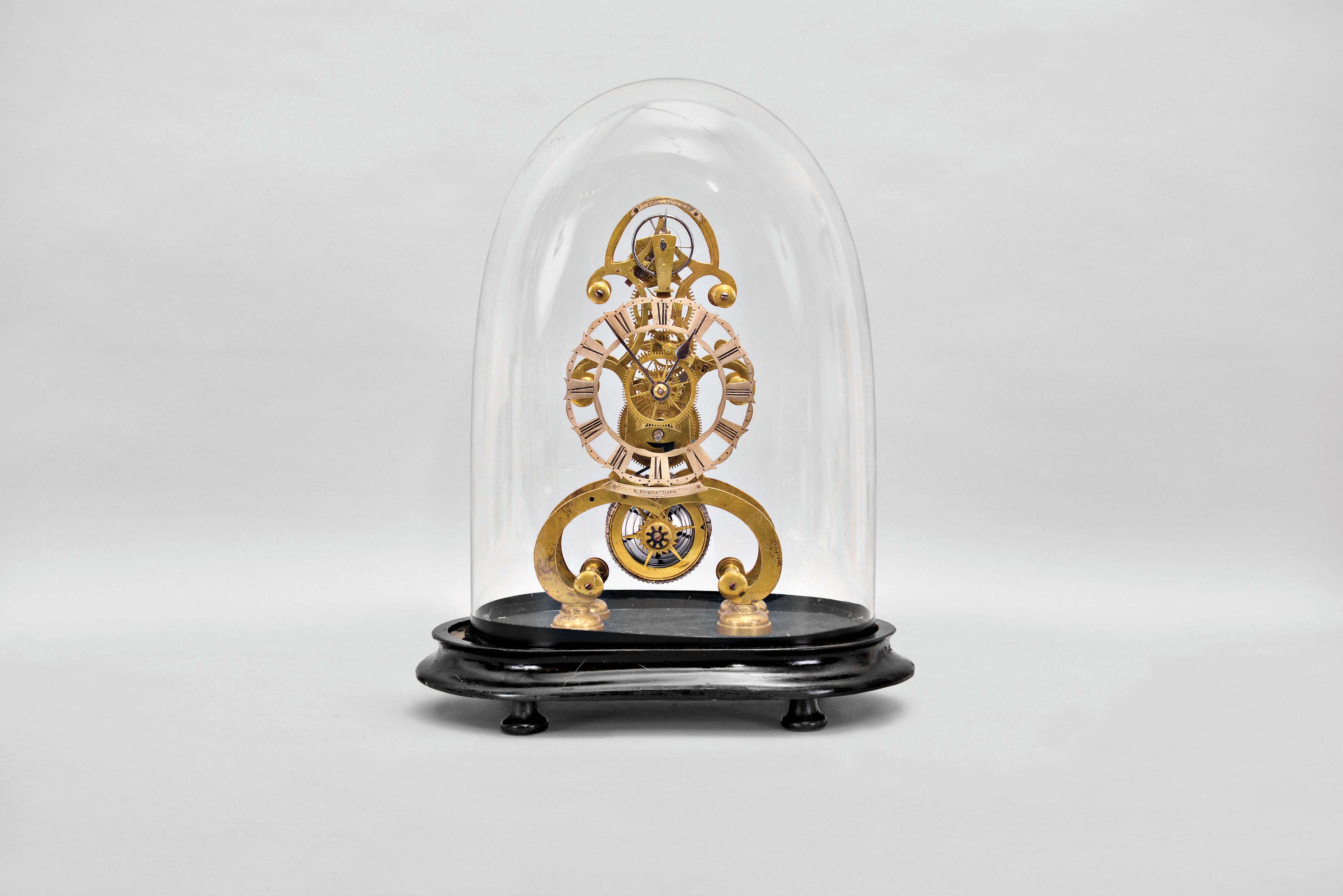 E. Fisher, Bath, England, an attractive, small skeleton clock with lever escapement, the finely fretted brass frames well proportioned and finished, fusee movement with six spoke crossings, skeletonized barrel, jeweled lever escapement and steel balance, Roman numeral skeletonized silvered dial, and with plate engraved "E. Fisher Bath" below, steel spade and poker hands, mounted to an ebonized wooden base with glass dome — Antique Clocks Price Guide