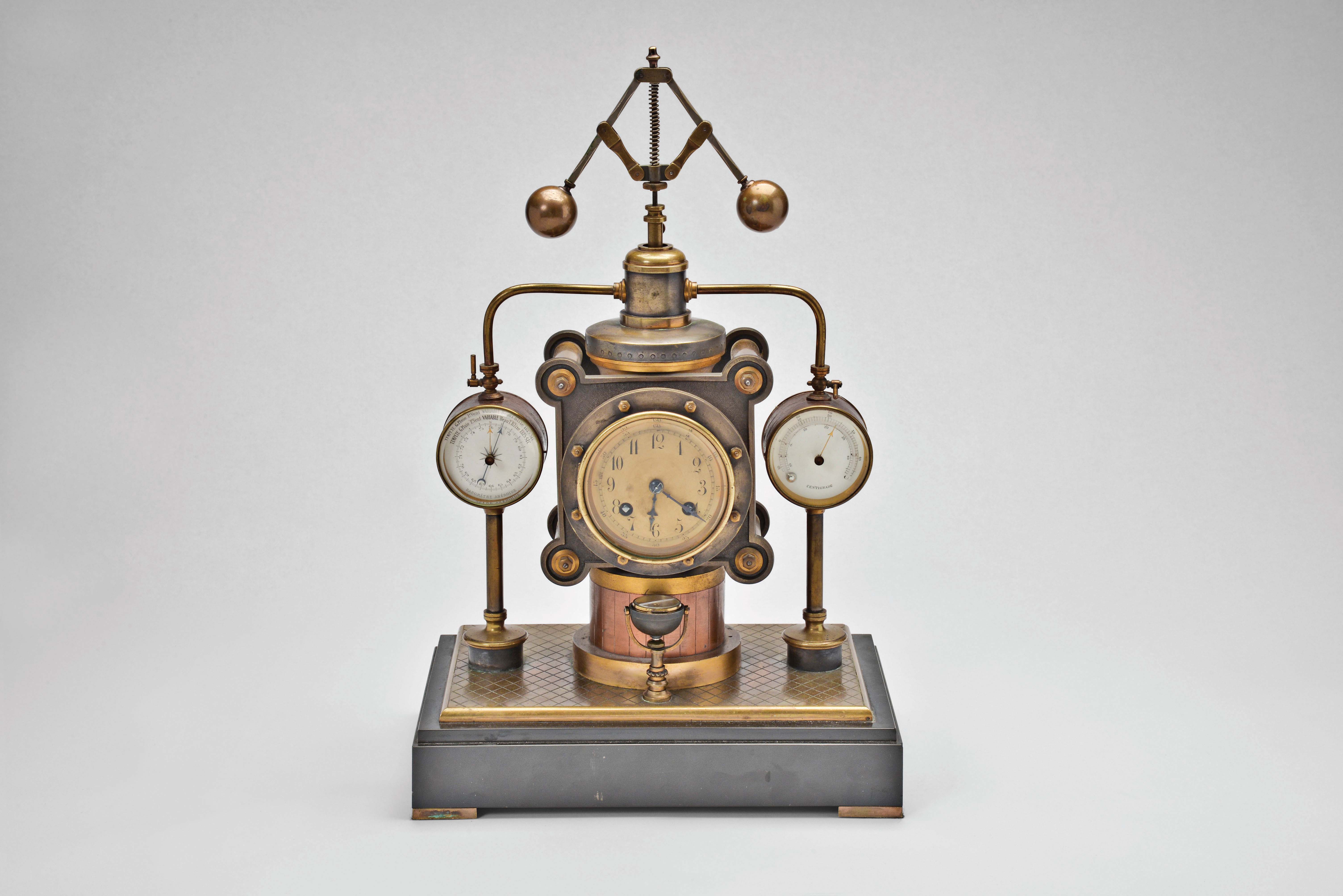 France- Andre Romain Guilmet, a rare Industrial steam boiler compendium with centrifugal governor pendulum, the stepped black slate base supporting a compass on a decorative stand, before a boiler with gilt and patinated silver surfaces and ribbed, copper base matching the clock case, the top having a cylindrical chamber with vent pipes attached to gauge form, flanking, white dialed thermometer and barometer, and concealing the helical suspension spring controlling the centrifugal governor form pendulum, Arabic numeral gilt dial, blued steel distaff hands, and 8 day pendule de Paris time and strike movement with Guilmet's mark and modifications — Antique Clocks Price Guide