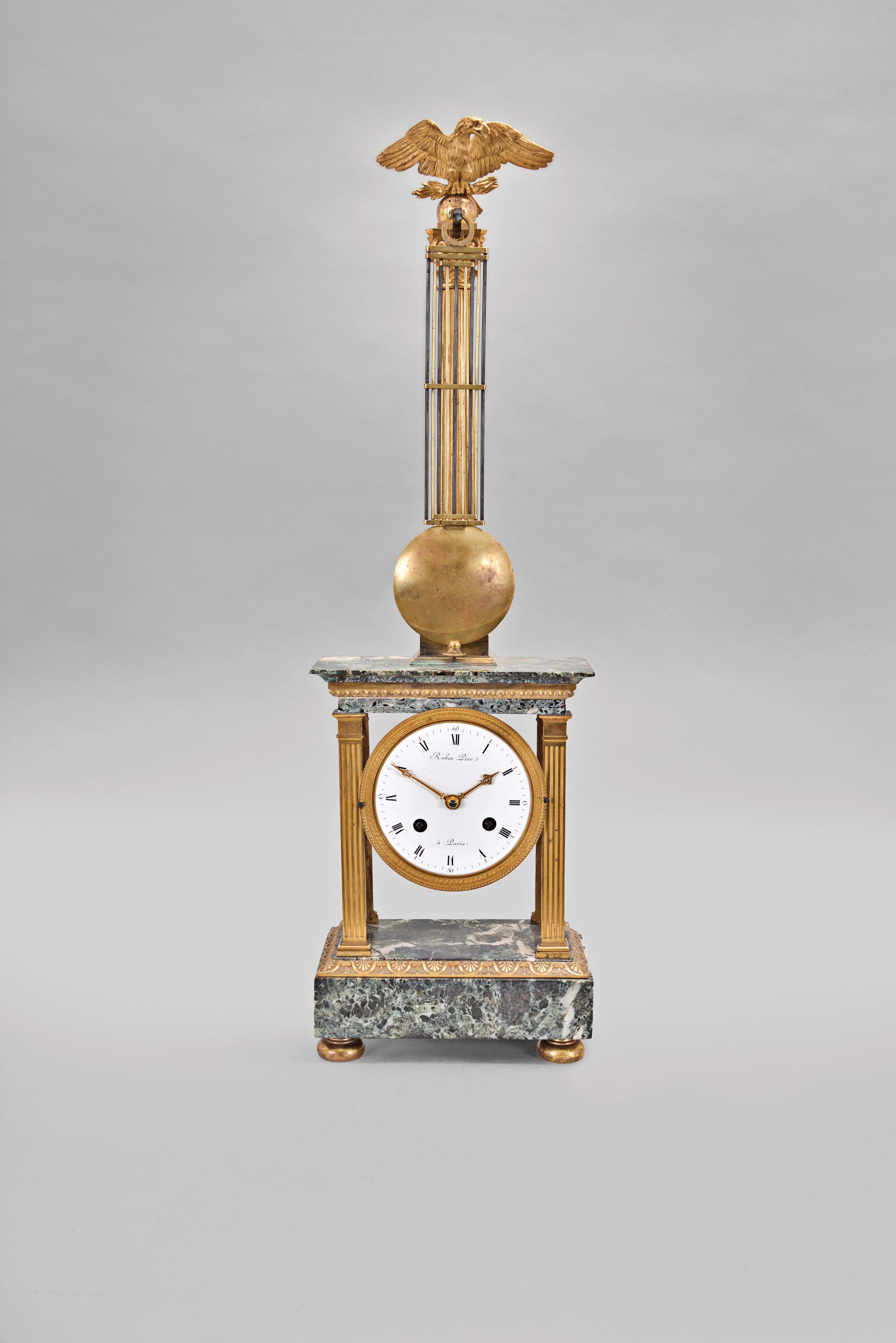 Robin Pere, a Paris, a marble and gilt bronze mystery clock, the variegated, green marble, portico style case with fluted pilasters flanking the dial, and supporting the entablature, surmounted by a gilt column with eagle finial, with knife edge stud for suspending the gridiron pendulum, signed, Roman numeral white enamel dial with pierced and engraved gilt hands, 8 day, two train movement striking the hours and half hour in passing, — Antique Clocks Price Guide