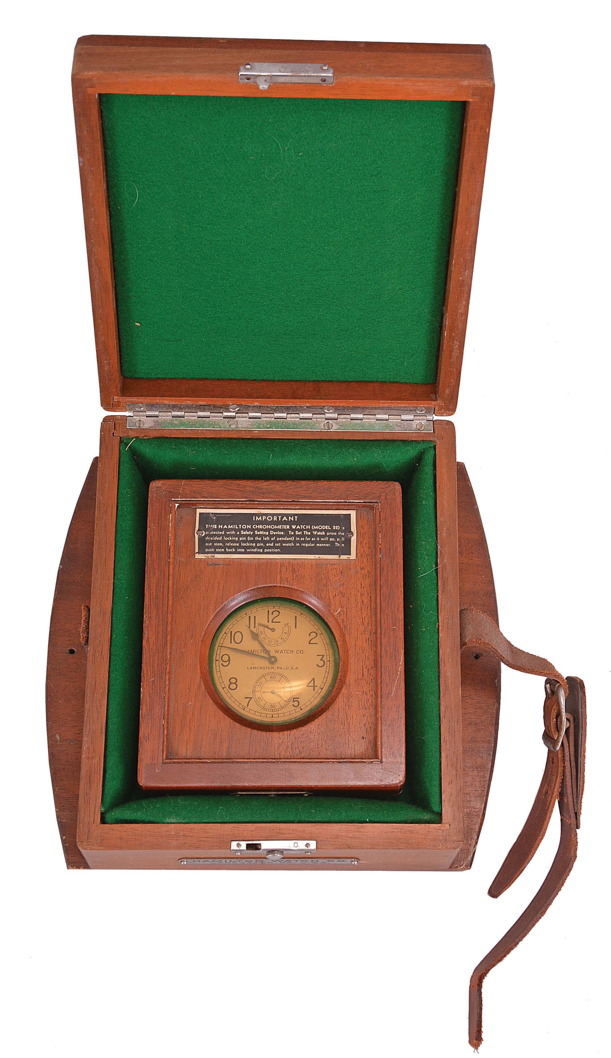 Hamilton Watch Co., Lancaster, Penn., model 22 chronometer watch with wind indicator, 35 size, 21 jewels, stem wind, pin set, adjusted to 6 positions and temperature, straight line damascened nickel plate movement, with lever escapement and micrometric regulator, Arabic numeral silvered metal dial, black steel spade and poker hands, serial #21697, the timepiece contained in mahogany boxes, the inner box with viewing aperture, c1940 — Antique Clocks Price Guide