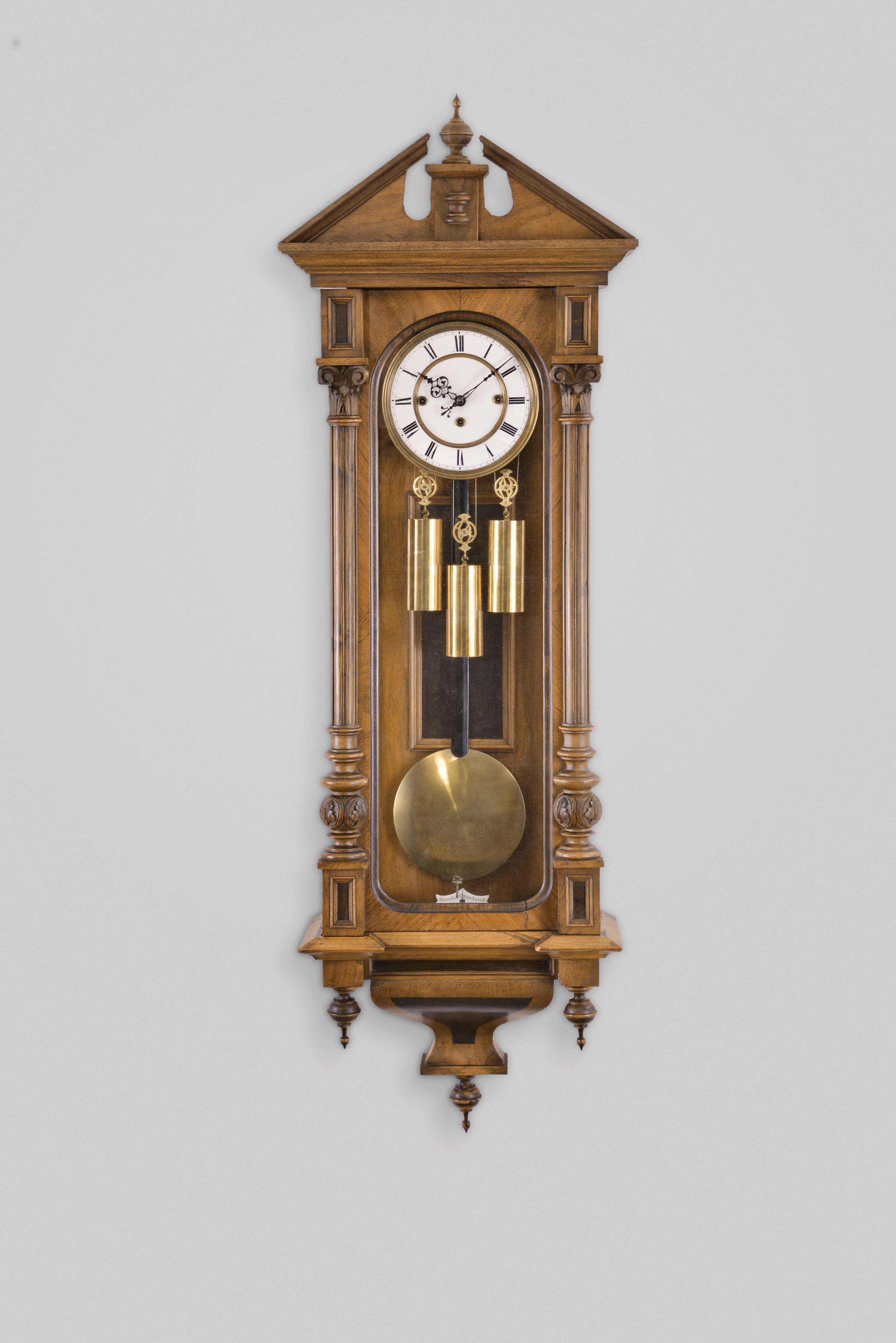 Gebrueder Resch, Ebensee, Austria, Vienna regulator wall clock, 8 day, time and quarter strike, weight driven movement in an Altdeutsch walnut veneer case with fluted half columns, white enamel dial, and blued steel hands. — Antique Clocks Price Guide