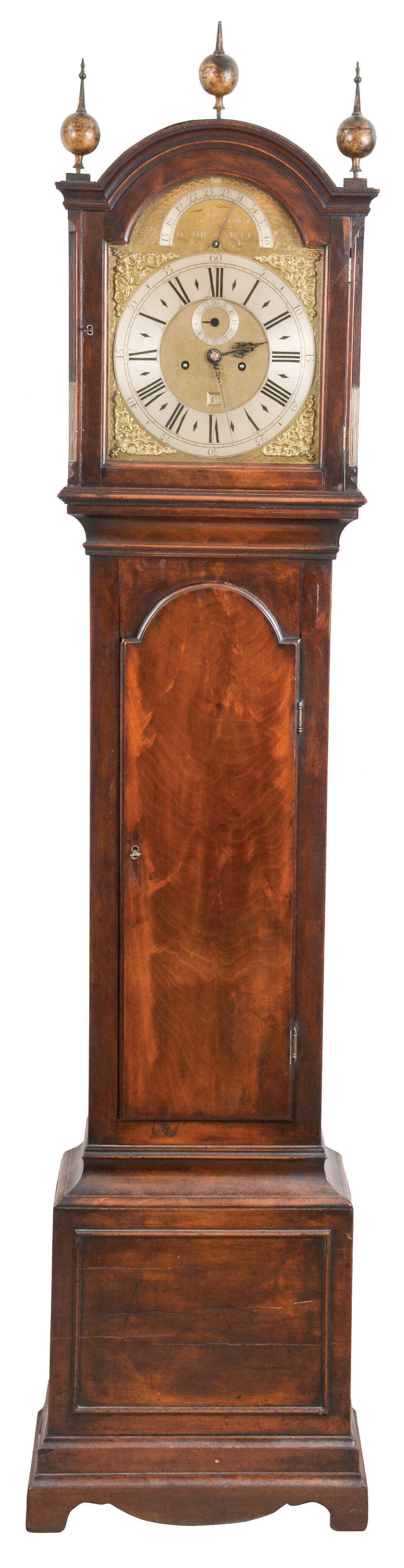 Fra. Robinson, In the Temple, England, tall clock, 8 day, time and strike, weight driven movement in a mahogany case with three brass finials, reeded corners with brass inserts and fretted sides flanking the hood, crotch mahogany trunk door and lower panel resting on applied bracket feet. The brass dial has maker's signature, cast brass corner spandrels and silvered chapter ring, calendar indicator, subsidiary seconds and pendulum rate adjustment. — Antique Clocks Price Guide
