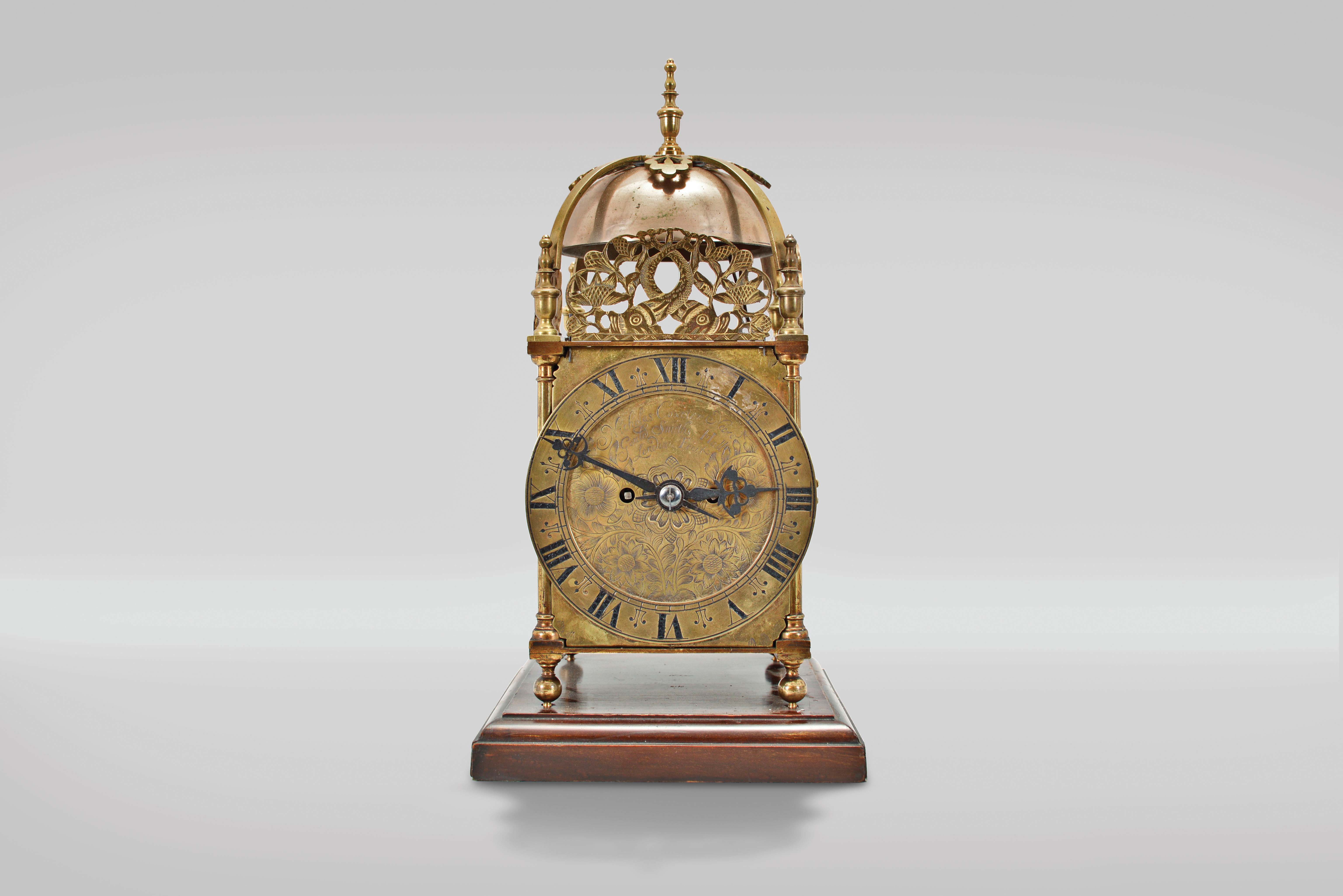 Payne & Co., 163 New Bond St, London, a Victorian, quarter chiming lantern clock, 8 day duration, with walnut base, brass case with turned finials, columns and feet, Roman numeral engraved brass dial with pierced steel hands, top with pierced frets, the front fret with engraving, cast brass bell strap suspending two large bells, the two train fusee movement with recoil escapement, striking ting tang quarters on two bells, and the hours on the smaller bell, back plate signed, serial #5054 — Antique Clocks Price Guide
