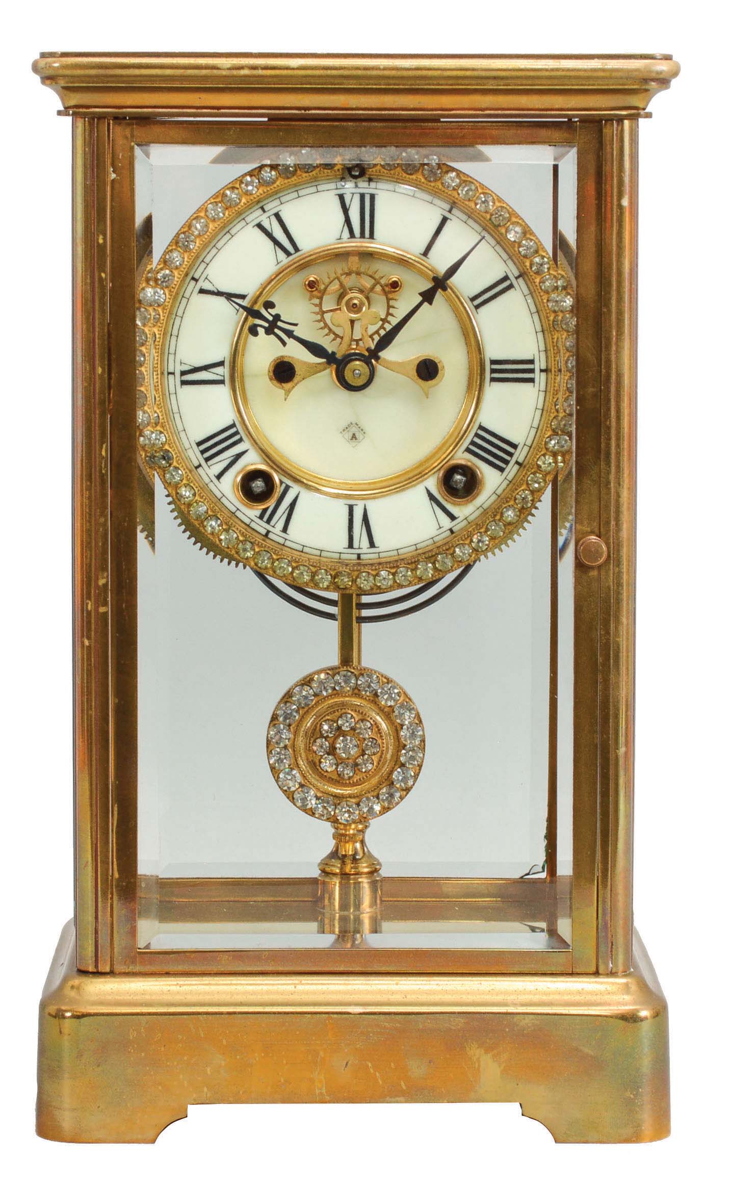 Ansonia Clock Co., New York, "Prism" crystal regulator shelf clock with a spring driven, 8 day, time and half hour strike movement with visible escapement, a jeweled sash and pendulum bob in a polished brass cased with beveled glass door and side panels. — Antique Clocks Price Guide