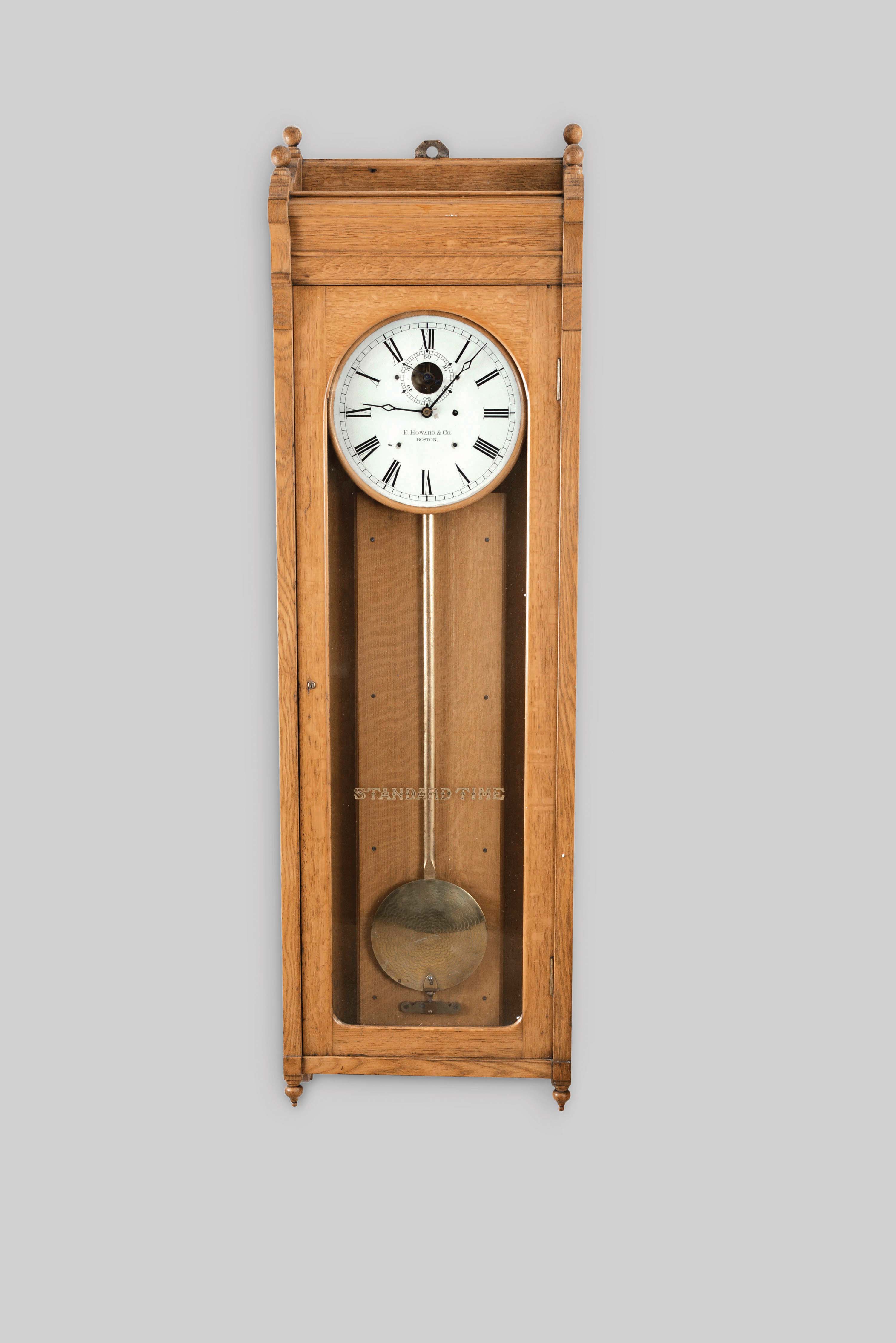 E. Howard & Co., Boston, Mass., "No. 89 Regulator", wall clock, 8 day, time only, weight driven movement with damascened pendulum disc in an oak case with a painted zinc dial — Antique Clocks Price Guide