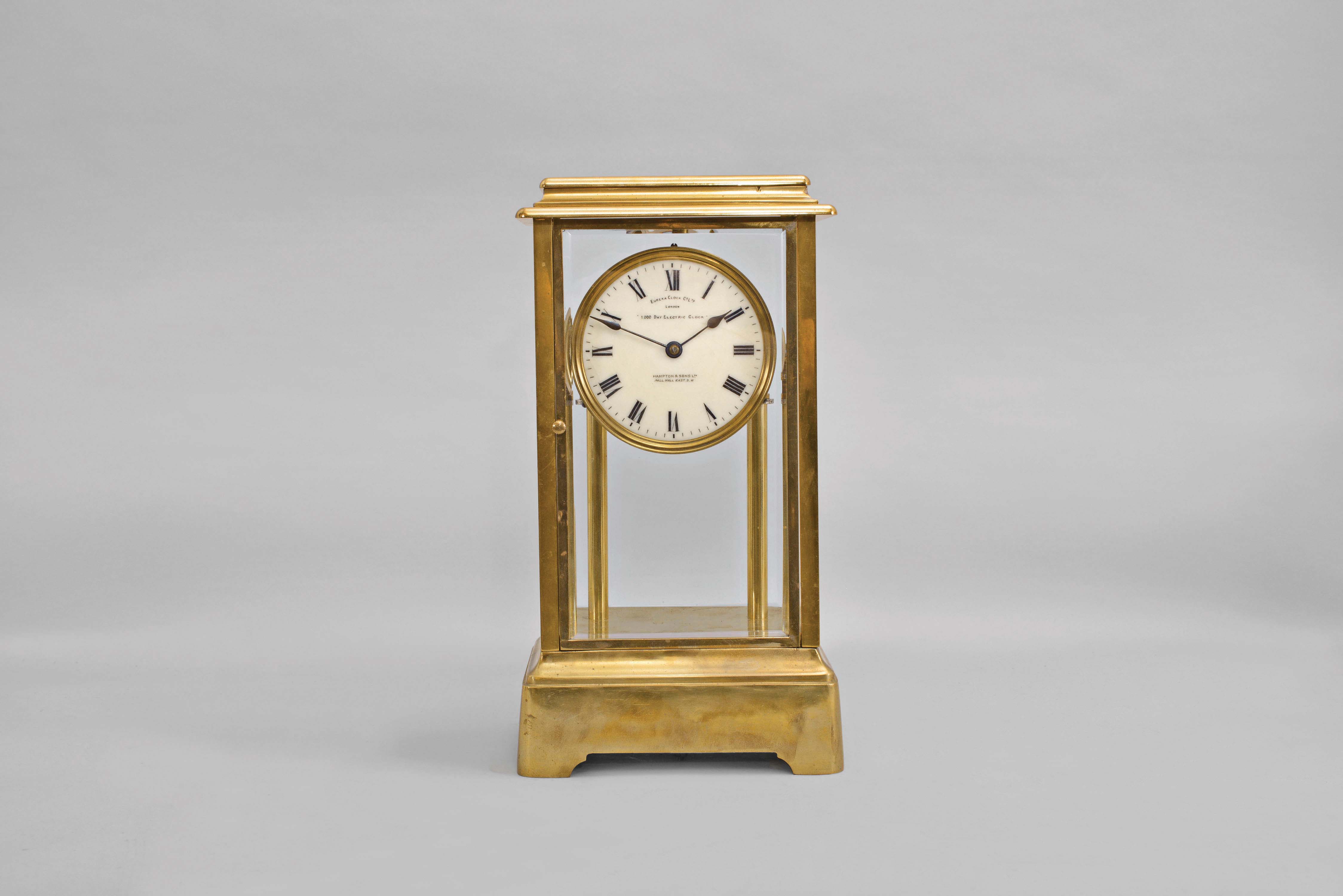 Eureka Clock Co., Ltd., London, type 1, 1000 day electric clock in a polished brass, four glass case, the batteries concealed in the base, signed Roman numeral white enamel dial, blued steel spade hands, and movement with spotted plates and large bimetallic balance, serial #2777 — Antique Clocks Price Guide