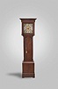 Woolley of Codnor, England, tall clock, 30 hour, time and strike, endless chain weight driven movement in an oak case with full columns topped by brass capitals flanking hood. The brass dial has silvered chapter ring, maker's signature on silvered disc and silvered calendar disc with serpentine hands.