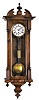 Germany, miniature Vienna style hanging regulator, 8 day, time only, weight driven movement in a softwood case with turned and fluted ornaments, brass clad pendulum and weight, white enamel dial with Roman numerals, and blued steel hands