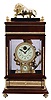 Chinese reproduction of a Ferris Wheel falling ball gravity mystery timepiece. The balls move down an inclined plain through the top of clock on the Ferris wheel and supply weight to run the clock. The balls exit the case and fall into a draw below to be placed on the rack to keep the clock going.