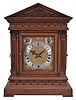 Winterhalder & Hofmeier, Schwarzenbach, Germany, bracket clock, 8 day, time and gong strike with chime playing on eight bells, spring-driven movement in an oak architectural case with fluted pilasters, frieze resembling ashlar, tympanum with carved scroll design, brass dial plate with applied cast spandrels, silvered chapter ring with Roman numerals, subsidiary rate adjustment and chime / silent dials, blued steel hands.