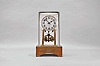 Jahresuhrenfabrik, Germany, an unusual year going mantel clock with torsion pendulum, wooden base with applied brass ornament, with conforming, rectangular, cut glass dome containing the 400 day timepiece with deadbeat escapement, Arabic numeral silvered dial, blued steel hands, and unusual four ball pendulum