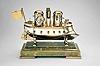 France, possibly Andre Romain Guilmet, a rare silvered and gilt brass, automated, battleship form compendium, the vessel bow with ram, fourteen cannon, and four anchors, the gilt deck with capstan containing a compass, two revolving gun turrets, one having an 11 jewel lever timepiece, with roman numeral silvered dial and blued steel trefoil hands, the other with aneroid barometer, also with silvered dial, the stacks with mounted Fahrenheit and Centigrade thermometers, the stern with ships wheel and flag, above the articulated rudder and revolving propeller, a movement concealed in the ship's hull providing power to the turrets and propeller, which may be started and stopped at will by a projection attached to the rudder, all mounted to a rectangular, molded, green onyx base with gilt trim and feet