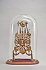Modern reproduction skeleton clock, 8 day, time and strike with chime on eight bells, triple fusee spring driven movement in a pierced brass frame mounted on a velvet covered, cavetto molded wood base, all under a glass dome.