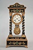 France, an indescribably outrageous mid 19th century portico clock, the stepped base, entablature and top inlaid with brass, mother of pearl, and green and pink dyed bone fragments, with stamped brass ornament and moldings trimming the ebonized case, twist turned columns with stamped capitals and bases, and trimmed with stamped brass vines, gilt, rococo revival style bezel with roman numeral white enamel dial, gilt gridiron pendulum with ornament matching the bezel, and 8 day, two train pendule de Paris movement striking on a bell