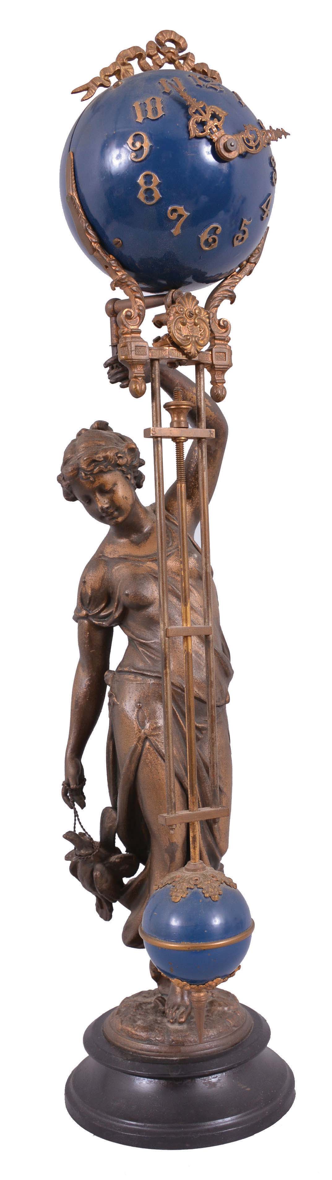 Ansonia Clock Co., New York, "Huntress" swinging mystery clock, 8 day, time only, spring-driven movement mounted inside a brass sphere with cast ribbon ornament and applied Arabic numerals, Louis XV style hands, the lower section in gridiron style with smaller sphere at the bottom, and held aloft by a patinated spelter figure of a young woman carrying game birds. — Antique Clocks Price Guide