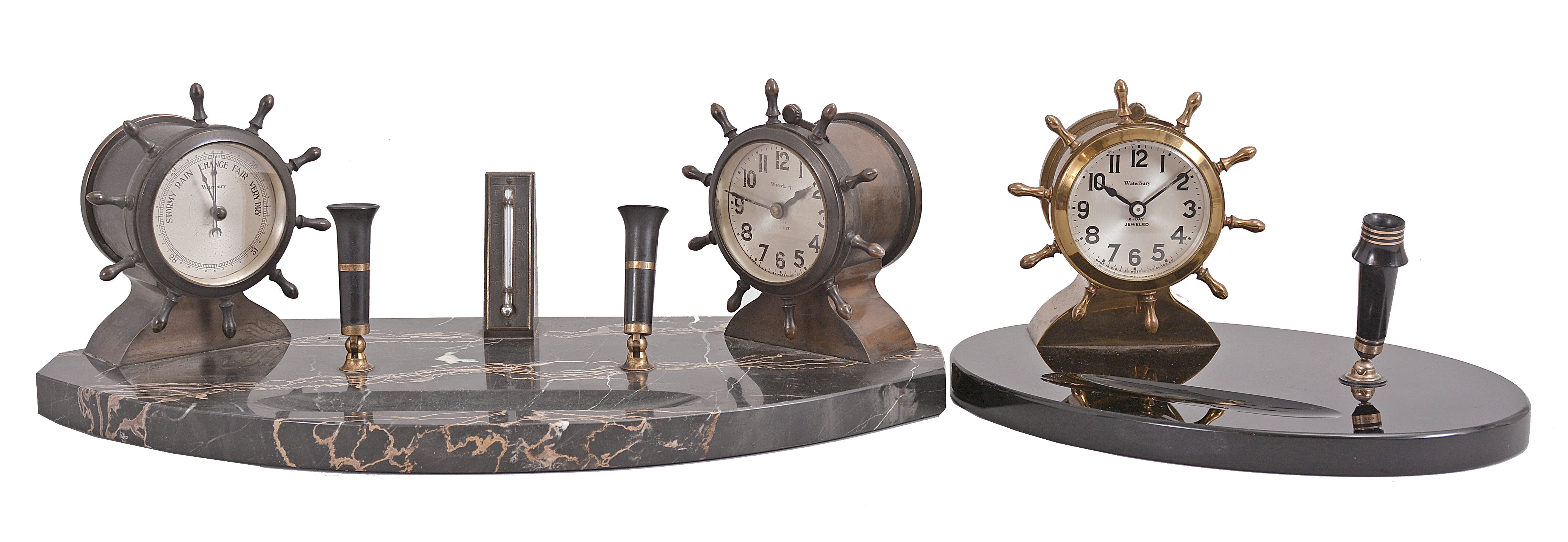 Clocks- 2 (Two): (1) Waterbury Clock Co., Waterbury, Conn., "Desk Set No. 1", 8 day, time only, spring driven jeweled movements in a yacht wheel form metal case on a black onyx base with pen holder, c1929; (2) Waterbury Clock Co., Waterbury, Conn., "Desk Set No. 3", 8 day, time only, spring driven jeweled movements in a yacht wheel form case on a black marble base with pen holder, thermometer, and barometer, c1929 — Antique Clocks Price Guide