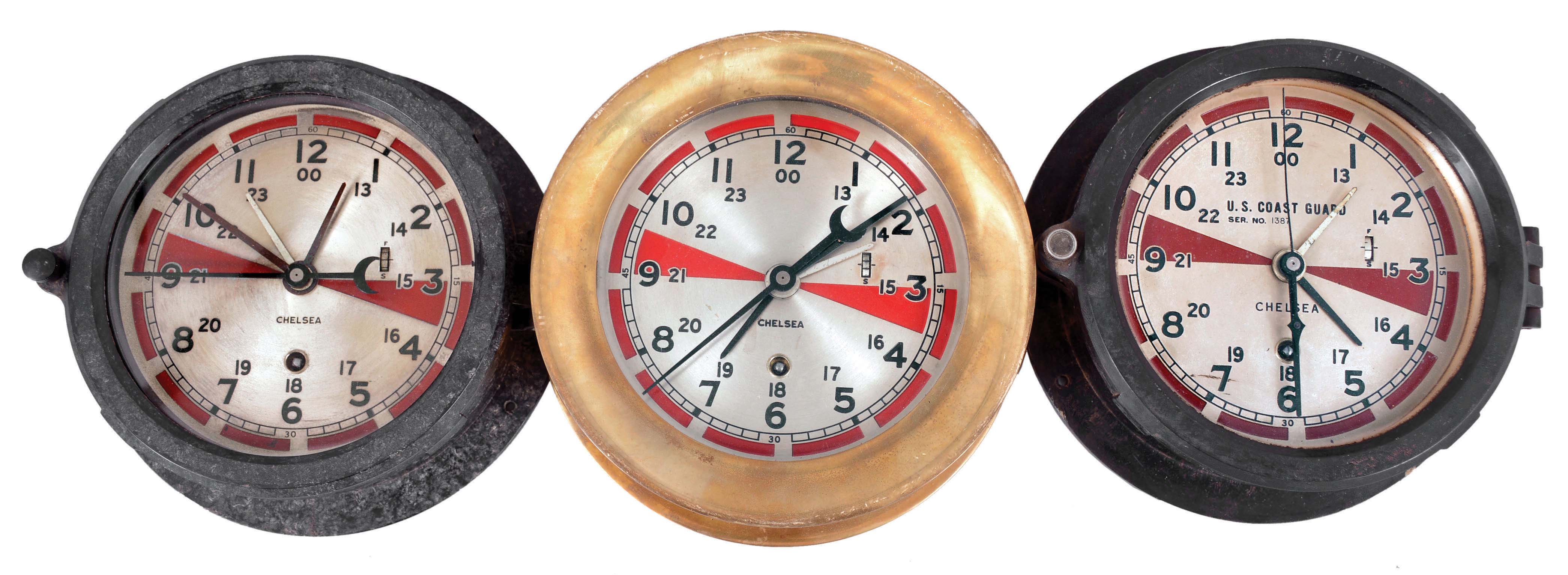 Clocks- 3 (Three) Radio Room: Chelsea Clock Co., Boston, "Radio Room" timepieces, 8 day, time only, spring-driven balance wheel movements with center seconds and secondary hour hand for Greenwich Mean Time, two in black phenolic cases and one in a brass case, all with hinged bezels, silvered 5.5 inch dials showing 12 and 24 hours, and red zones denoting periods of radio silence to monitor for distress calls. — Antique Clocks Price Guide