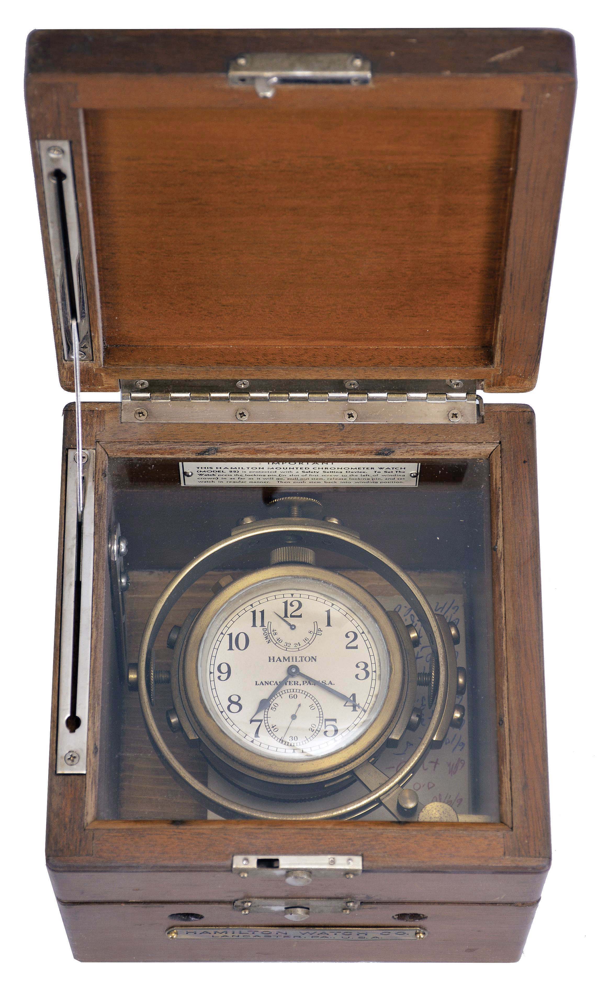 Hamilton Watch Co., Lancaster, Penn., model 22 chronometer watch with wind indicator, 35 size, 21 jewels, stem wind, pin set, adjusted to 6 positions and temperature, straight line damascened nickel plate movement, with lever escapement and micrometric regulator, Arabic numeral silvered metal dial, black steel spade and poker hands, the timepiece contained in a gimbaled bowl, and mounted in a three tier mahogany box, movement marked "U.S. Navy Bu. Ships", serial #2F7907 — Antique Clocks Price Guide
