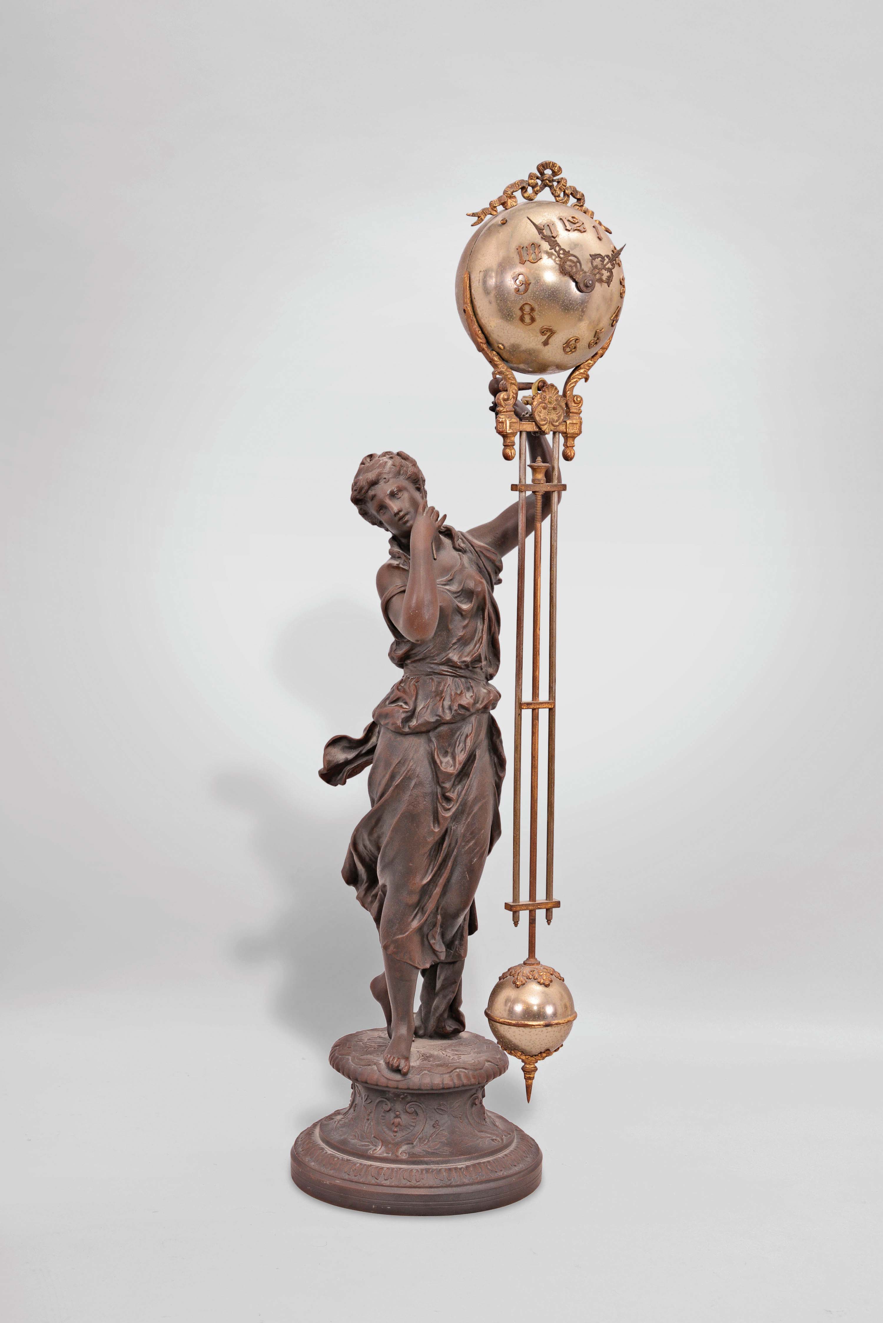 Ansonia Clock Co., New York, "Juno" figural swinging clock, 8 day, time only, spring driven movement mounted inside a nickel plated brass sphere with cast ribbon ornament and applied Arabic numerals, with Louis XV style hands, all supported by patinated spelter figure of a Roman goddess standing atop a cast spelter pedestal. — Antique Clocks Price Guide