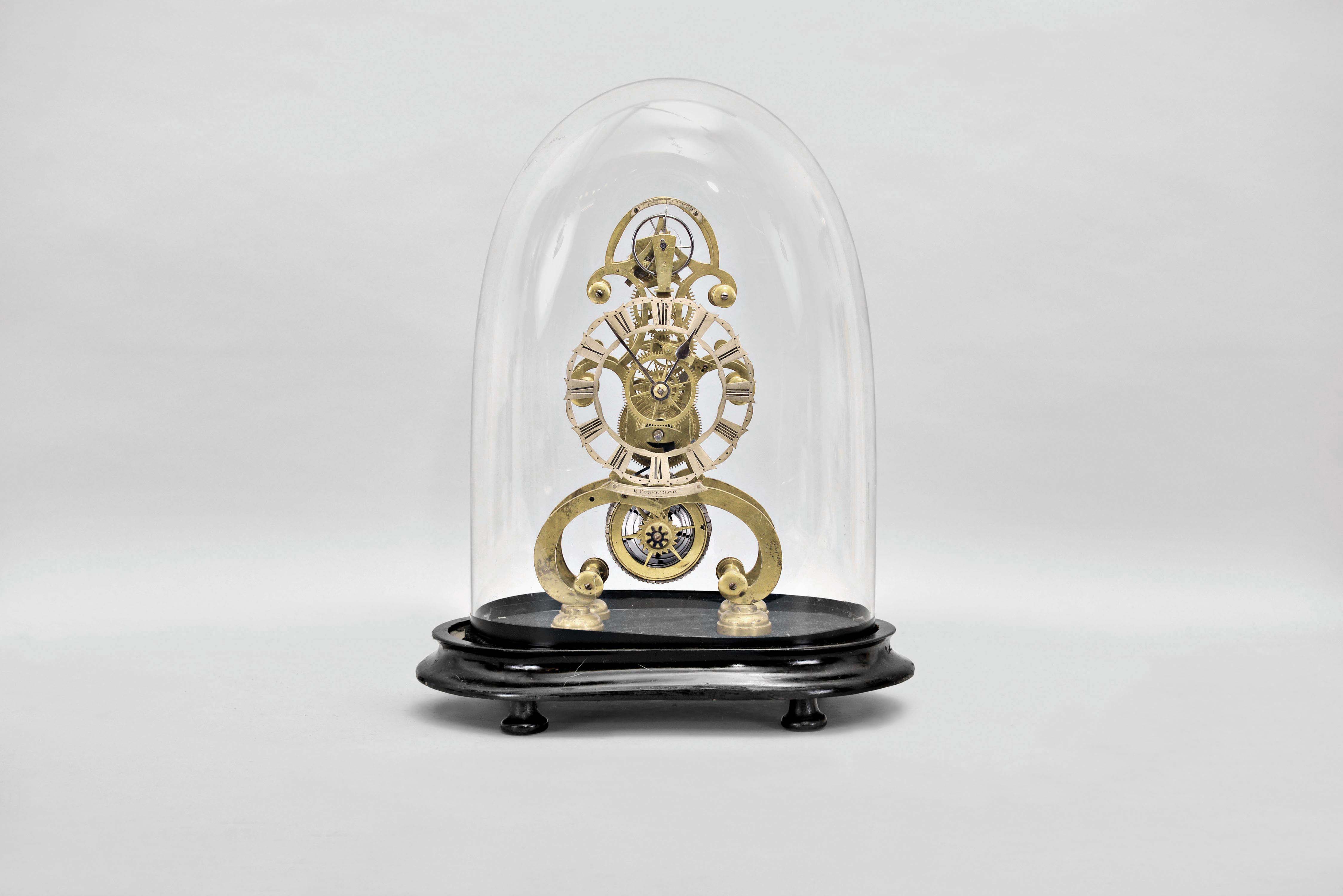 E. Fisher, Bath, England, an attractive, small skeleton clock with lever escapement, the finely fretted brass frames well proportioned and finished, fusee movement with six spoke crossings, skeletonized barrel, jeweled lever escapement and steel balance, Roman numeral skeletonized silvered dial, and with plate engraved "E. Fisher Bath" below, steel spade and poker hands, mounted to an ebonized wooden base with glass dome — Antique Clocks Price Guide