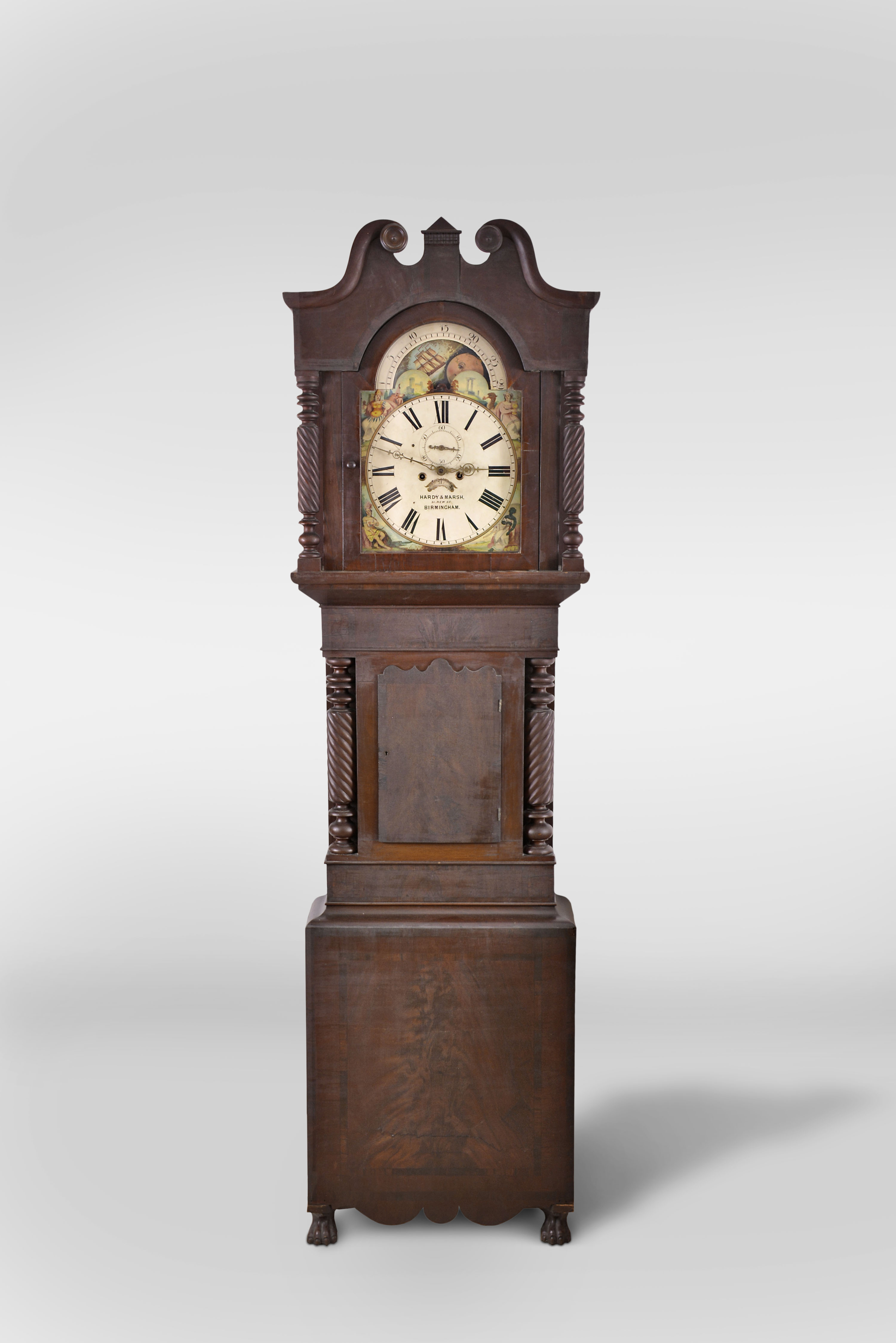 Hardy and Marsh, 51 New St, Birmingham, England, 8 day, time and bell strike, weight driven movement tall clock in mahogany case with rope turned full columns flanking hood and trunk door. The painted metal dial has moon phase, seconds bit and calendar. — Antique Clocks Price Guide