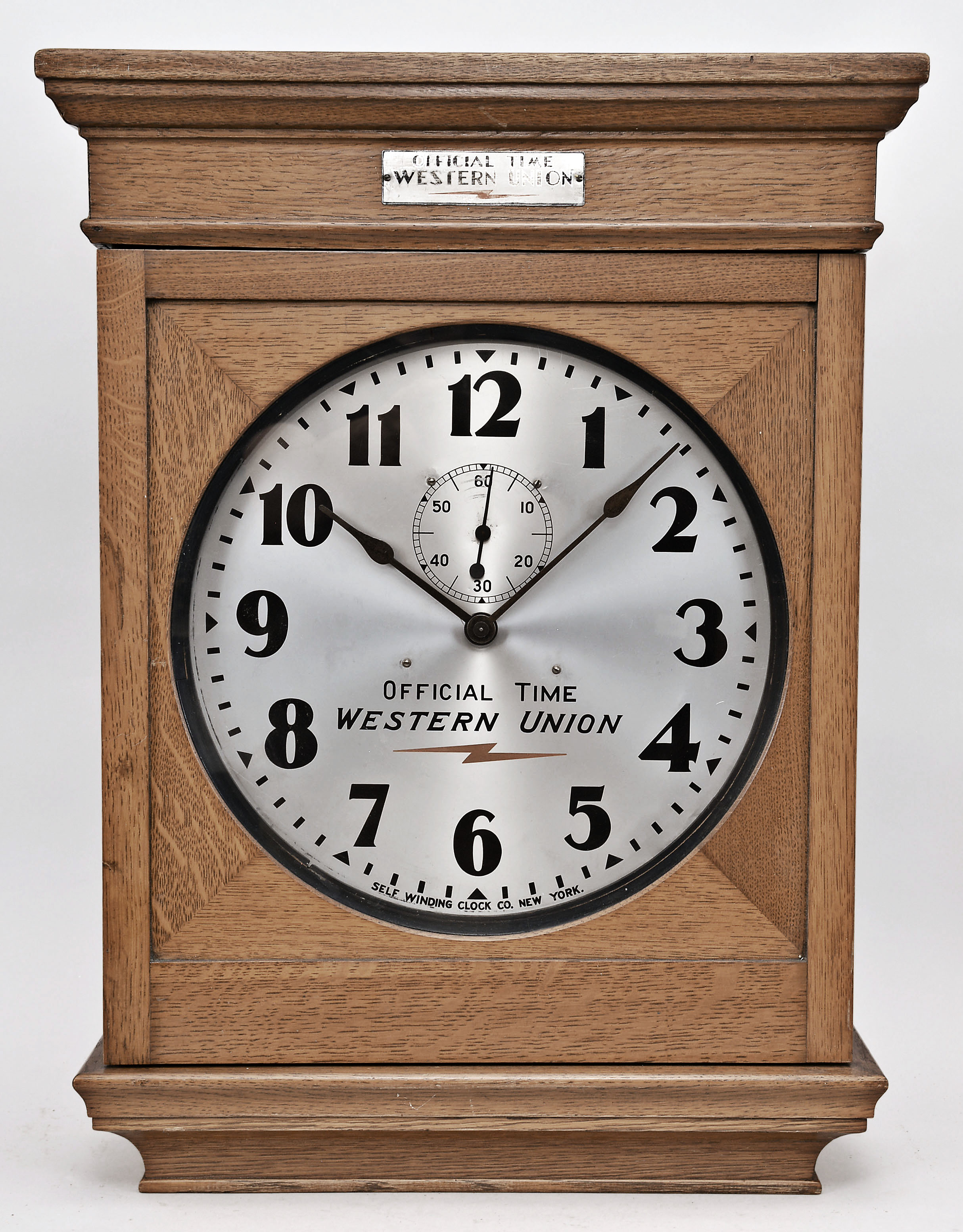 Self Winding Clock Company, New York, "No. 10-A Self Winding Clock", spring driven movement with deadbeat escapement and battery wind mechanism in an oak case with 14 inch aluminum dial reading "Official Time / Western Union ". — Antique Clocks Price Guide
