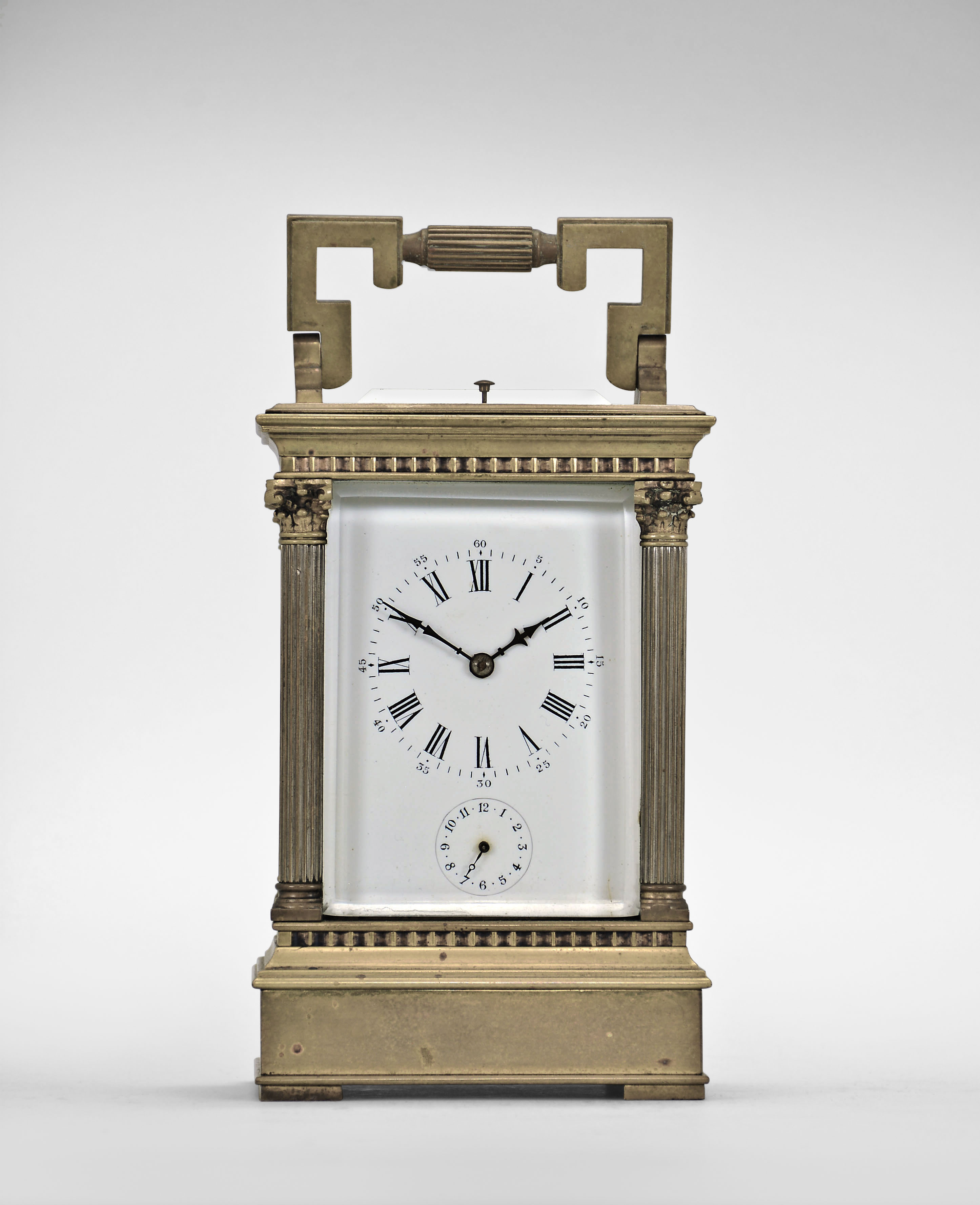 France, carriage clock, 8 day, time and strike with alarm and hour repeat, spring driven movement with lever platform escapement in an Anglaise case with stepped, molded base and cornice, the corners with Corinthian columns, and the top with carrying handle, Roman numeral white enamel dial, and blued steel distaff hands. — Antique Clocks Price Guide