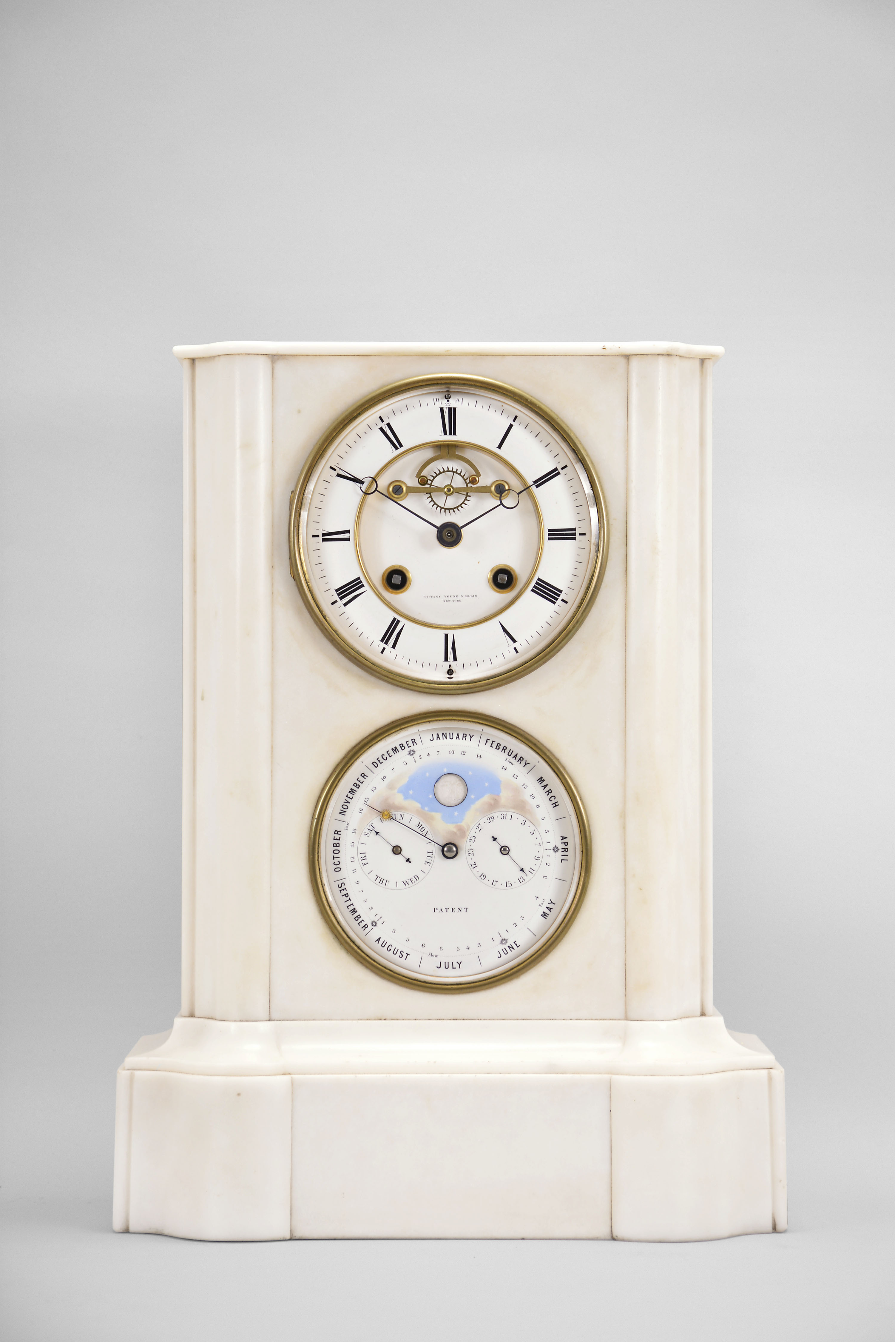A. Brocot and Delettrez, Paris, France, for Tiffany, Young & Ellis, New York, double dial calendar clock, 8 day, time and strike with rolling moon and calendar indicating day, date, and month perpetually, spring driven movement with visible Brocot escapement in a molded white marble case with white enamel dials, beveled glasses, and blued steel hands. — Antique Clocks Price Guide