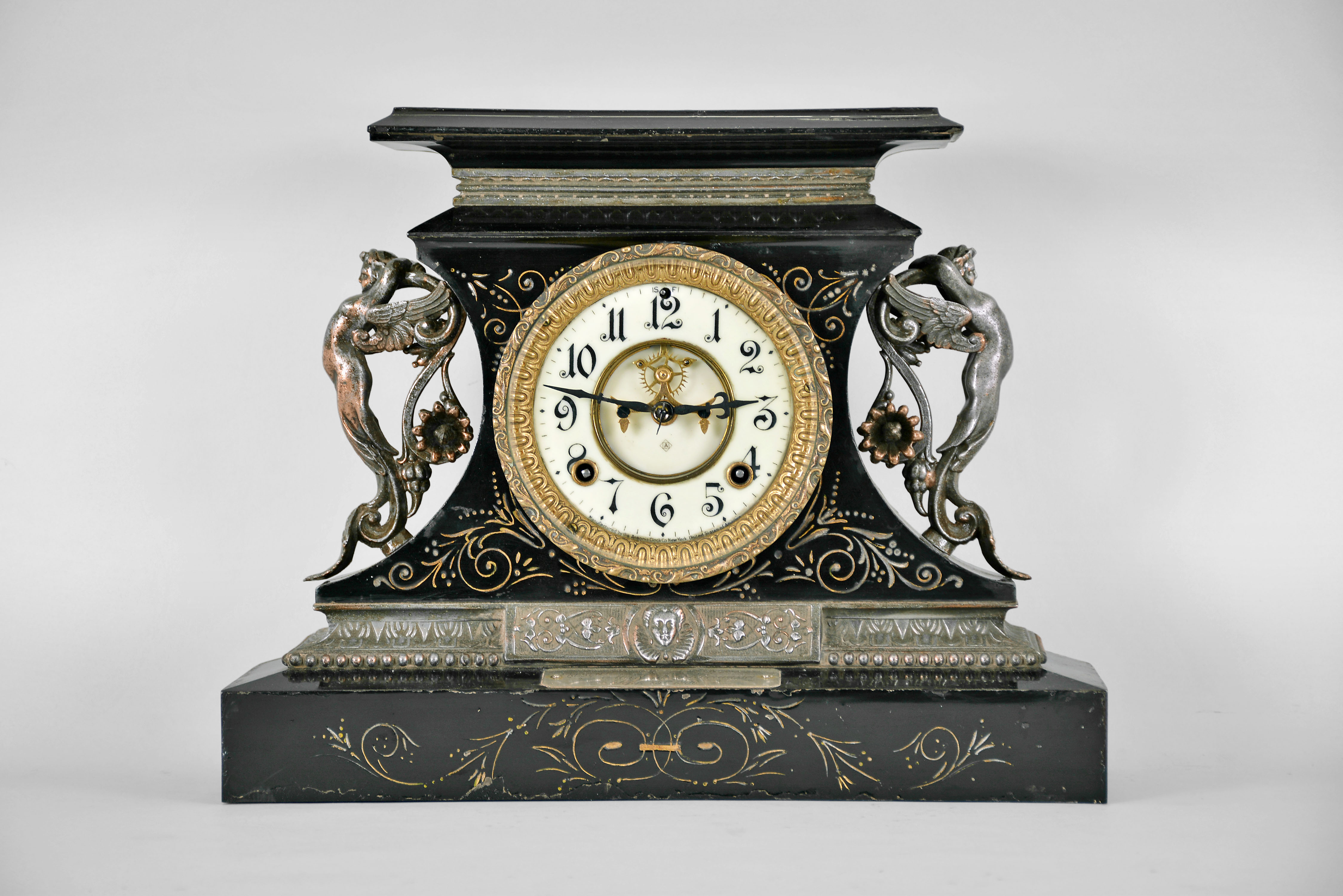 Ansonia Clock Co., New York, "Rosalind" 8 day, time and spring brass movement cast iron black mantel clock with visible escapement. A plaque on the case reads: "Presented by Mr. & Mrs. B. Uberwasser", Sept. 15th, 1906 ". — Antique Clocks Price Guide