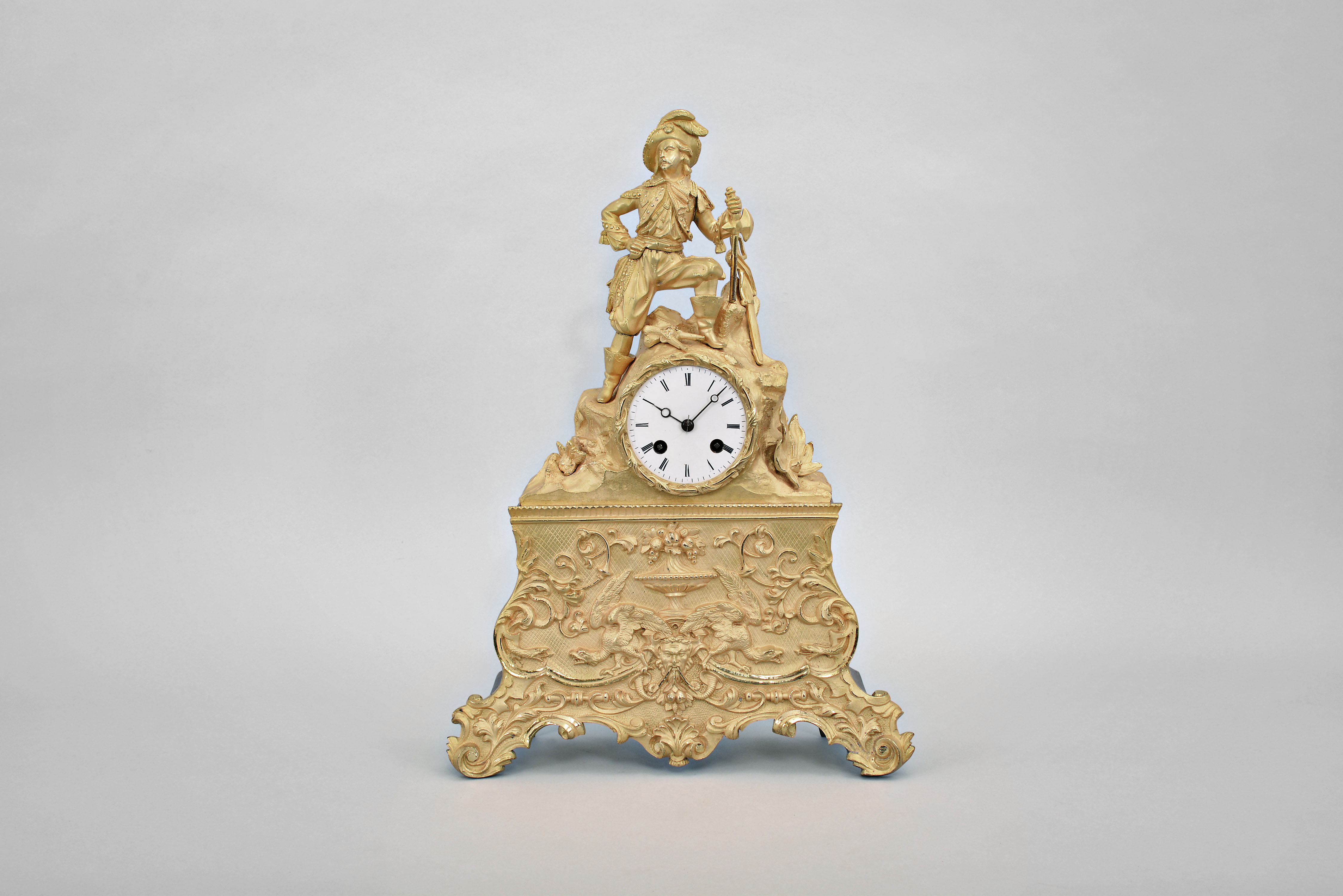 Japy Freres & Cie, Paris, figural mantel clock, 8 day, time and strike, spring driven pendule de Paris movement in an elaborate gilt metal case surmounted by a warrior leaning on an ax, a saber behind him, and a brace of pistols between his feet, 3 inch white enamel dial, and blued steel Breguet style hands. — Antique Clocks Price Guide