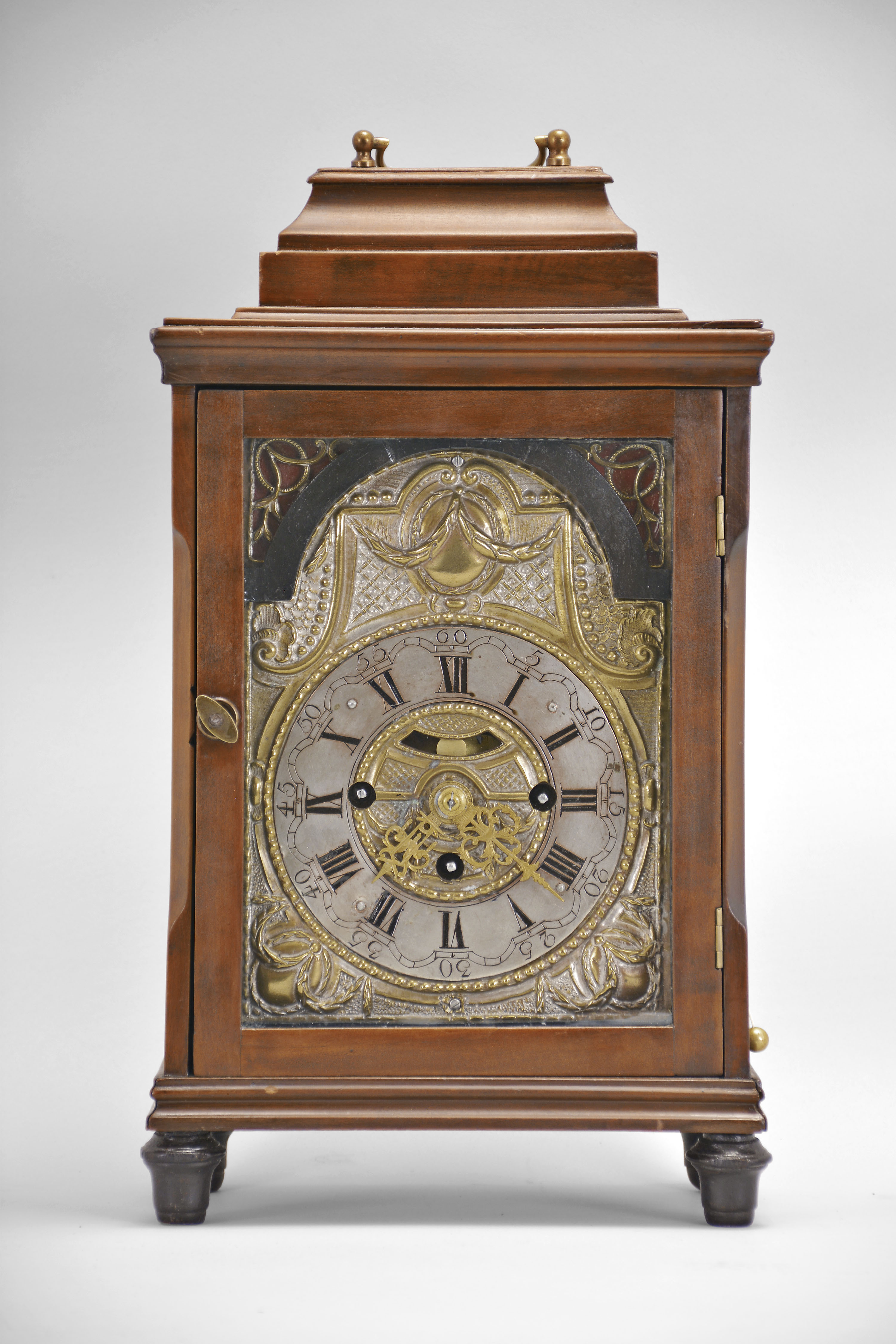 Austria, bracket clock, 30 hour, time and Viennese grand sonnerie strike, three train spring driven movement with verge escapement in hardwood case on ebonized turned feet, molded base and cornice, stop-chamfered front corners, glazed sizes, and stepped top with carrying handle, partially silvered brass dial surround with applied arcaded silvered chapter ring showing Roman numerals, aperture with faux pendulum, and pierced gilt hands. — Antique Clocks Price Guide