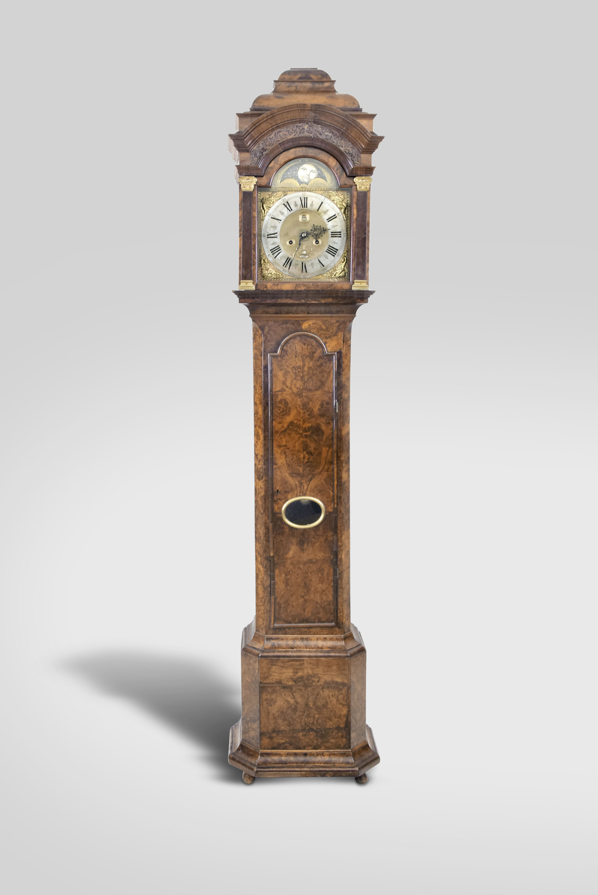 And. Vermeulen, Amsterdam, Netherlands, tall clock, 8 day, time and strike, weight driven movement in a burl walnut veneer case with stepped top, hood has frieze with blind fret and faux columns flanking door, trunk door with lenticle glass over faceted base resting on bun feet. The brass dial has silvered chapter ring, moon phase, calendar aperture and maker's signature under 6. — Antique Clocks Price Guide